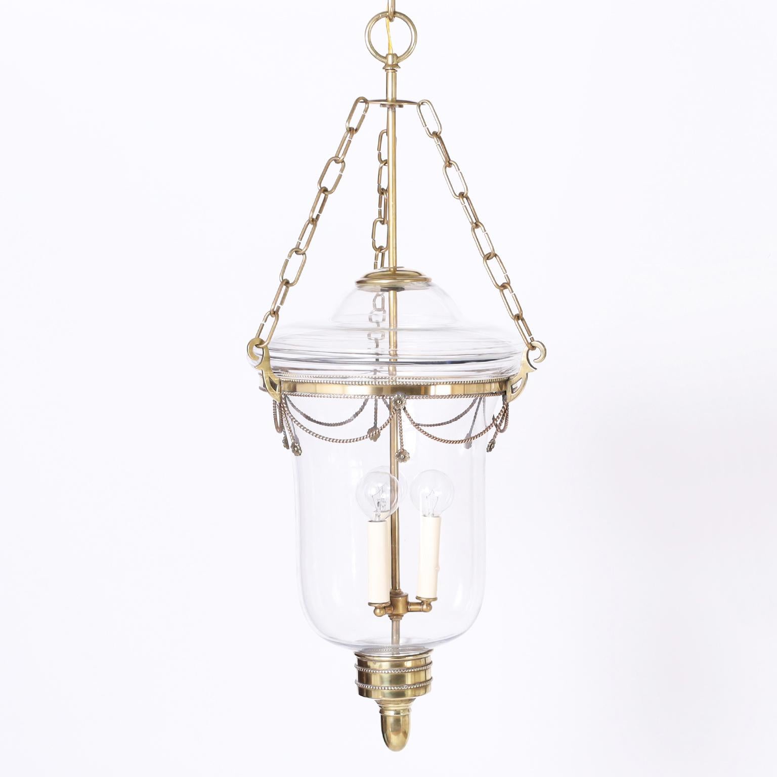 Standout pair of antique smoke bell light fixtures with classic form having three light clusters in hand blown glass globes with brass hardware featuring rope and flower decorations.