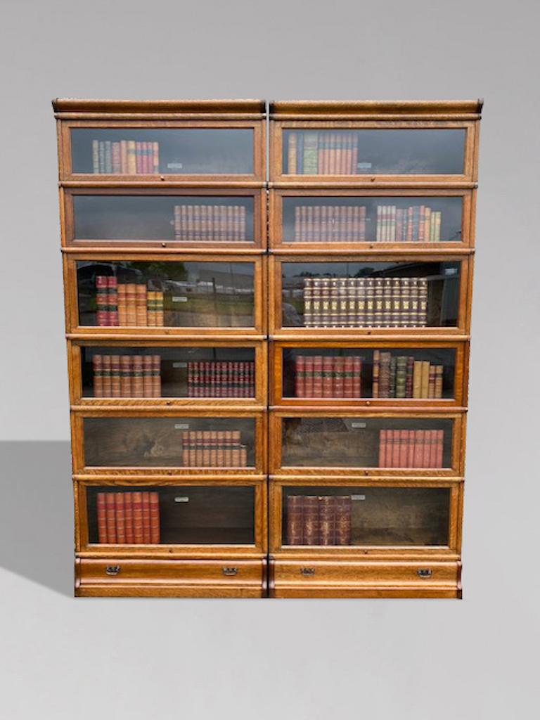 Una splendida coppia di librerie a otto sezioni in rovere massiccio dell'antica Globe Wernicke. La parte superiore con cornice modanata si trova sopra sei sezioni vetrate con porte in vetro originali, meccanismo originale e maniglie originali in