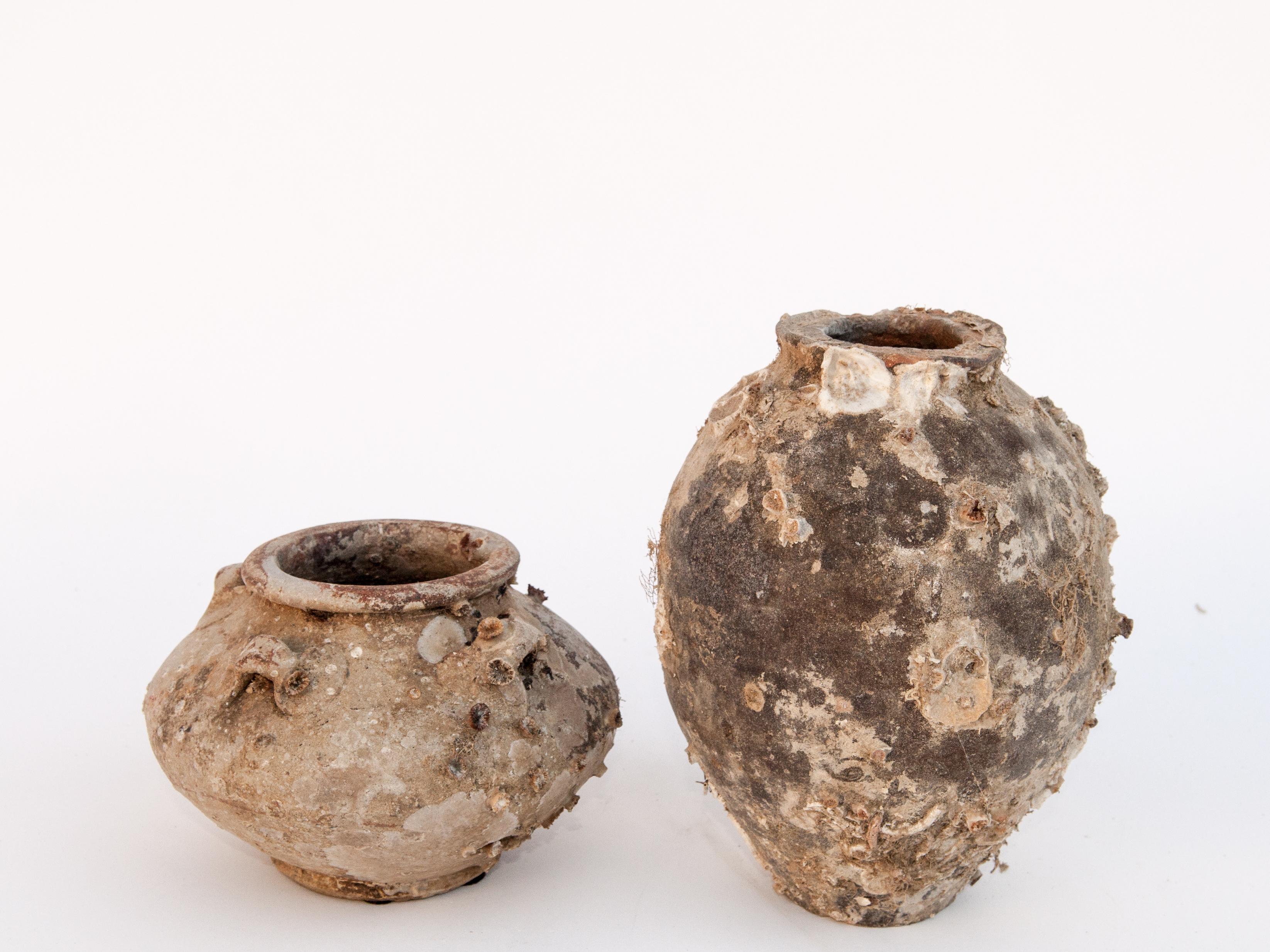 Pair of antique song dynasty jars with encrustations, China, 12th century. 4.5 and 7.75 inches tall.
These two Song Dynasty jars were salvaged from shipwrecks off the coasts of Malaysia and Indonesia. Such jars and other ceramics made up an