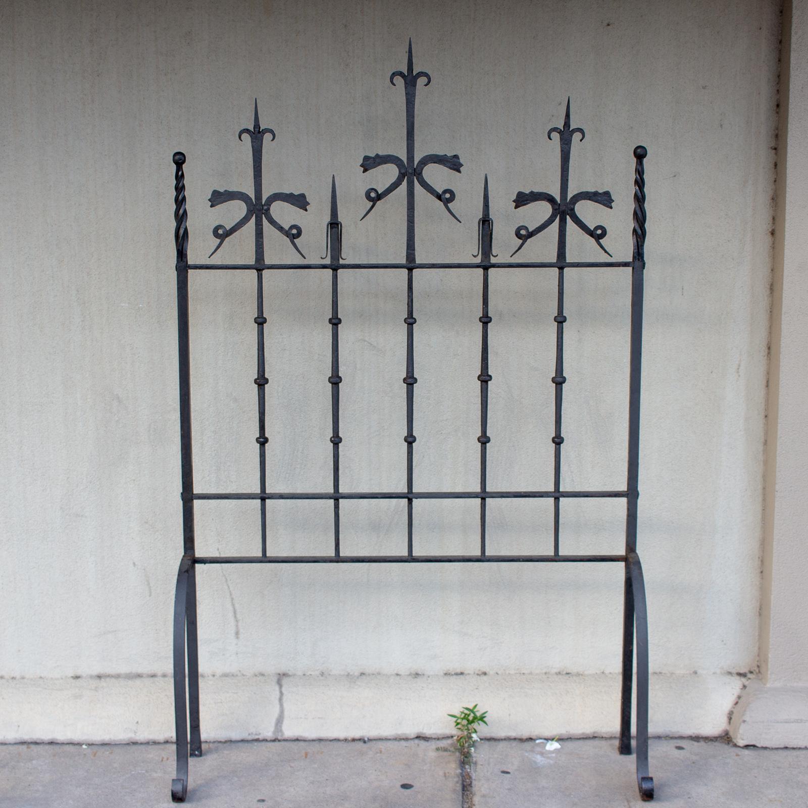 This pair of iron screens was sourced in Italy, but we believe they are Spanish in origin. The details are wonderful, from the arrow spears to the serpentine decorations at the top as well as several twist details. The front feet of both screens are