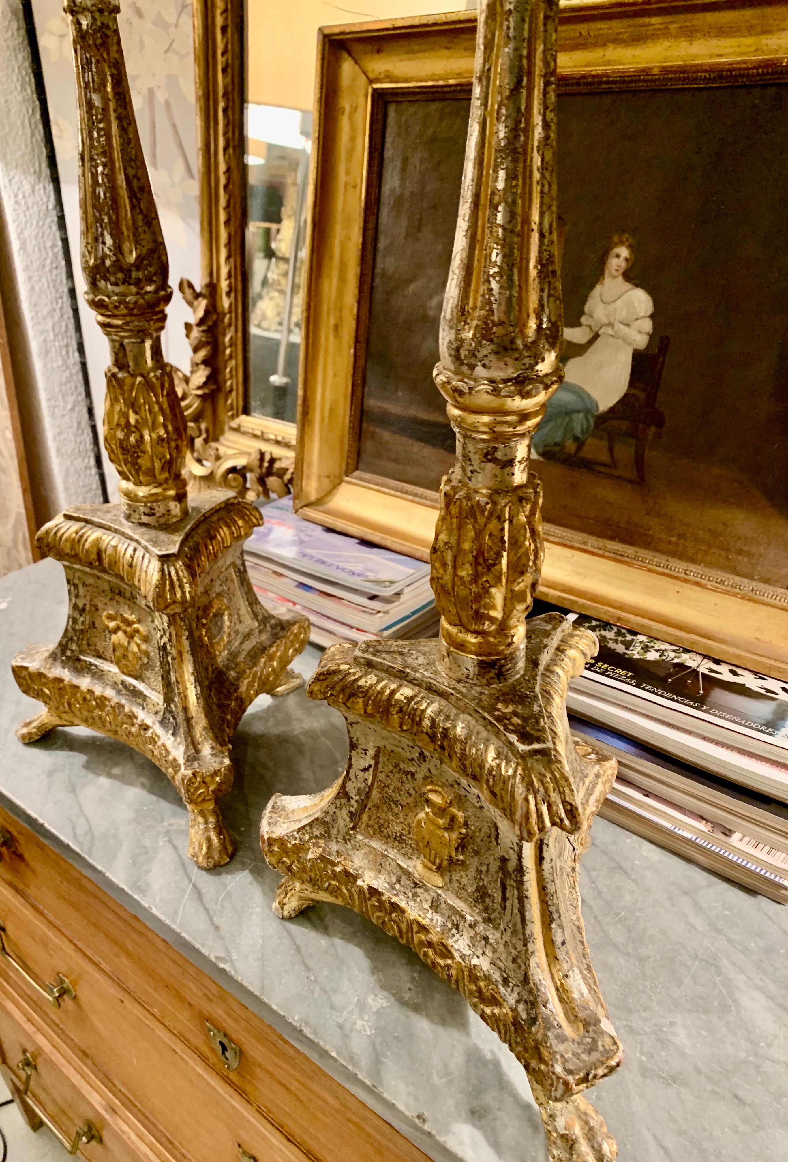 A pair of beautiful Spanish torcheros, probably the end of the 18th century, in gilt wood and silver wood, their base is triangular supported on legs in the shape of a lion's claw, they have a beautiful patina, and they have different decorative