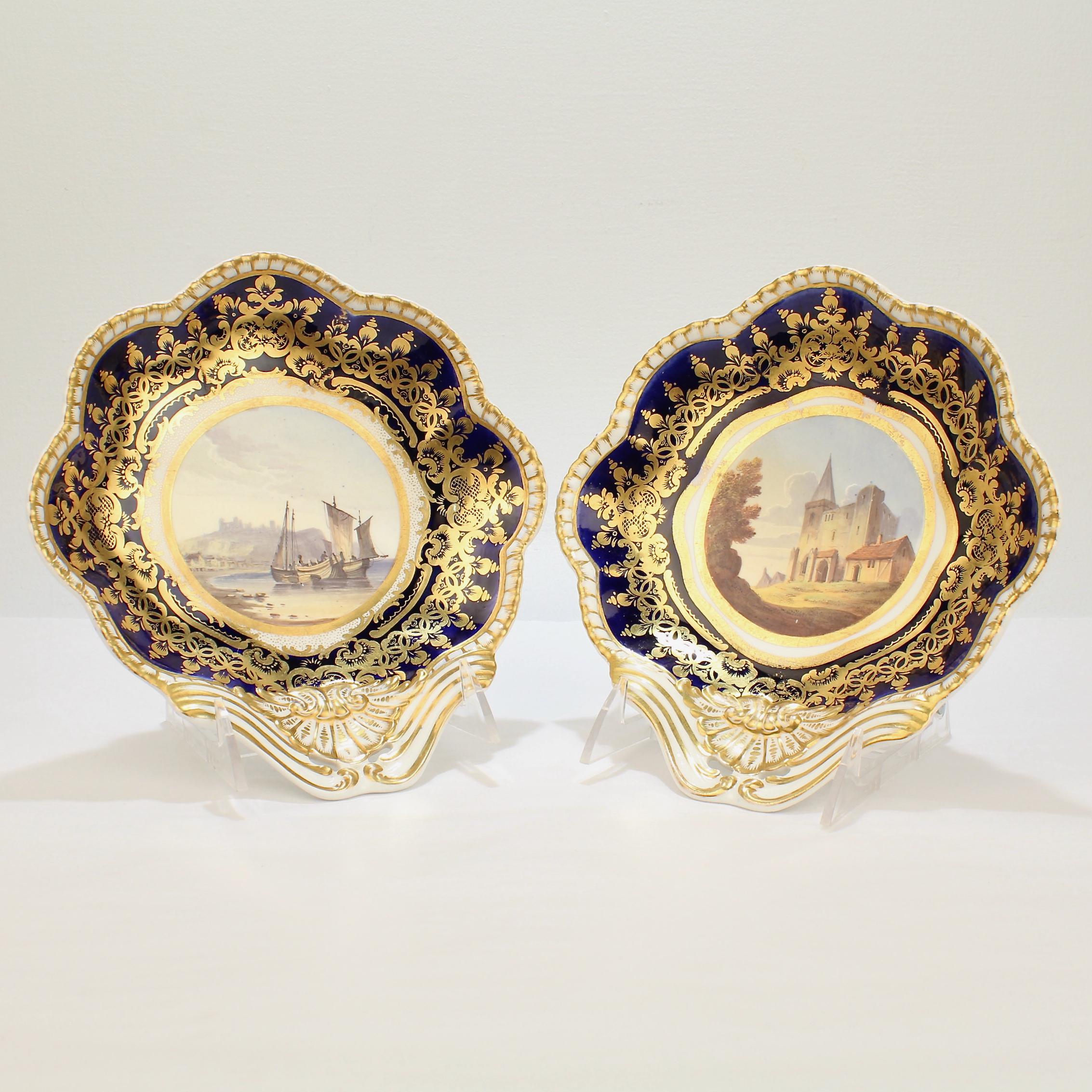 A very Fine pair of Spode porcelain shrimp bowls.

With rich gilding, underglaze cobalt blue borders, and hand painted topographical scenes at their centers.

One scene depicts fishing boats in the bay at Dover Castle. The other depicts a scene