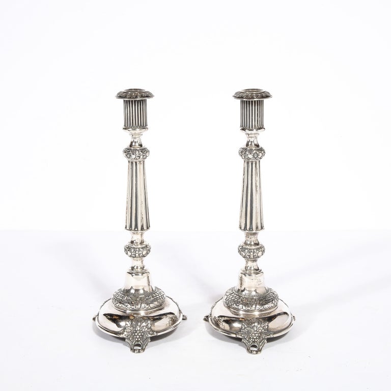 This elegant pair of early Antique sterling silver Sabbath candlesticks were realized in Russia circa 1910 by J. Ehrlich .They Sitting on three open form feet, they feature volumetric circular bases with stylized grape and vine motifs and undulating