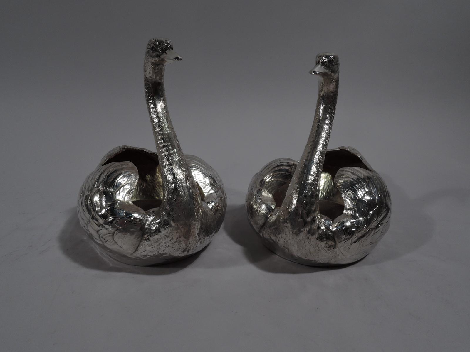 Pair of sterling silver swans. Made by Durgin (part of Gorham) in Concord, New Hampshire, circa 1920. Each: Fine feathering with downy plumed wings and scaly neck as well as closed bill and penetrating eyes. Hollow gilt-washed bodies to be filled