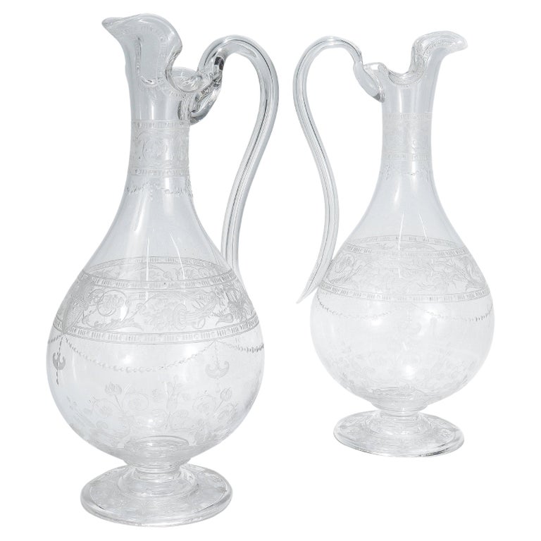 https://a.1stdibscdn.com/pair-of-antique-stourbridge-etched-engraved-glass-water-pitchers-or-decanters-for-sale/f_16102/f_333536621679088557892/f_33353662_1679088559356_bg_processed.jpg?width=768