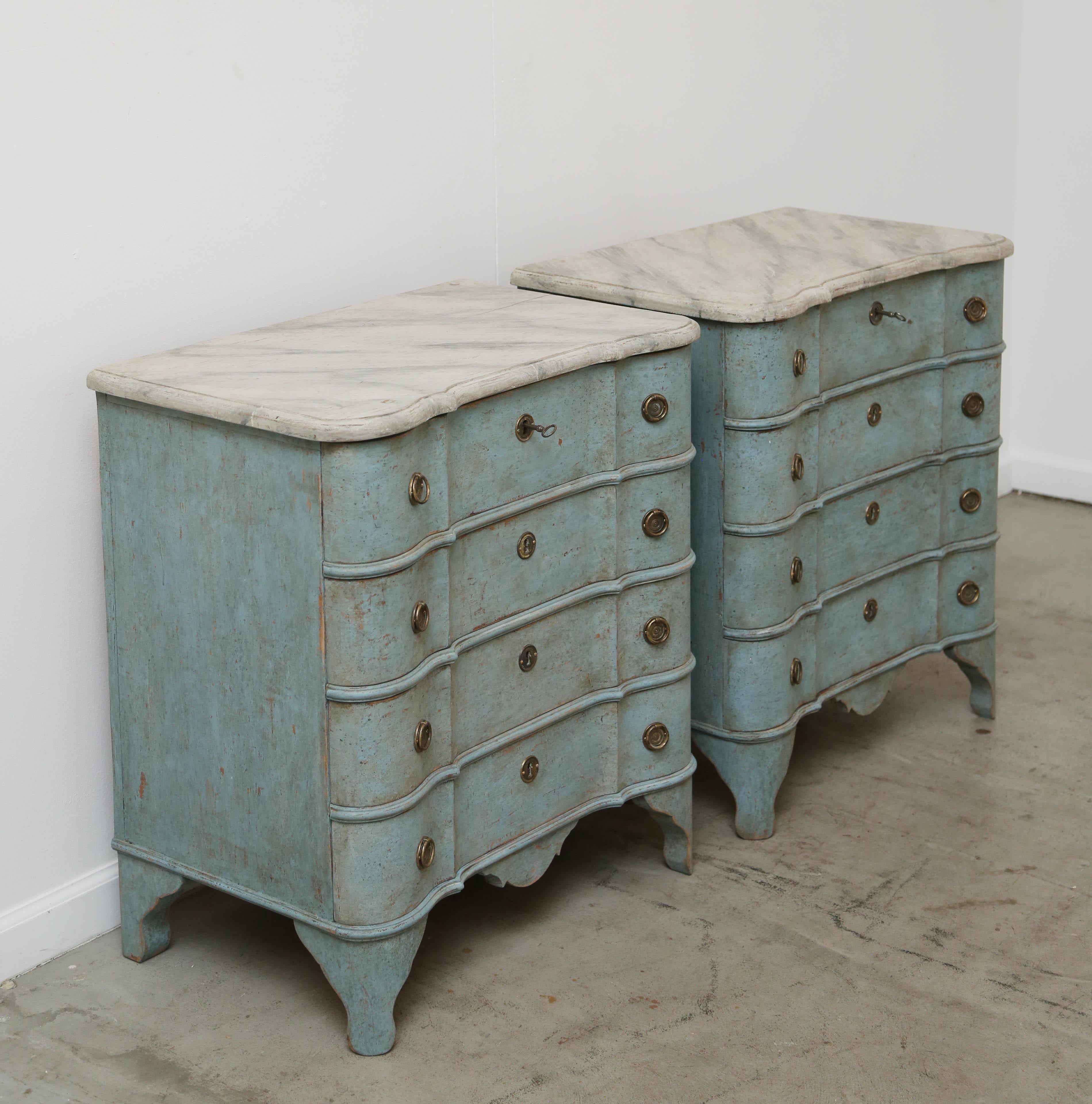 Pair of antique Swedish Baroque style small blue distressed painted chests with grey faux marble tops. The top has a lovely curved shape with rounded corners and semi round edge border. The four drawers have a curved serpentine shape with brass