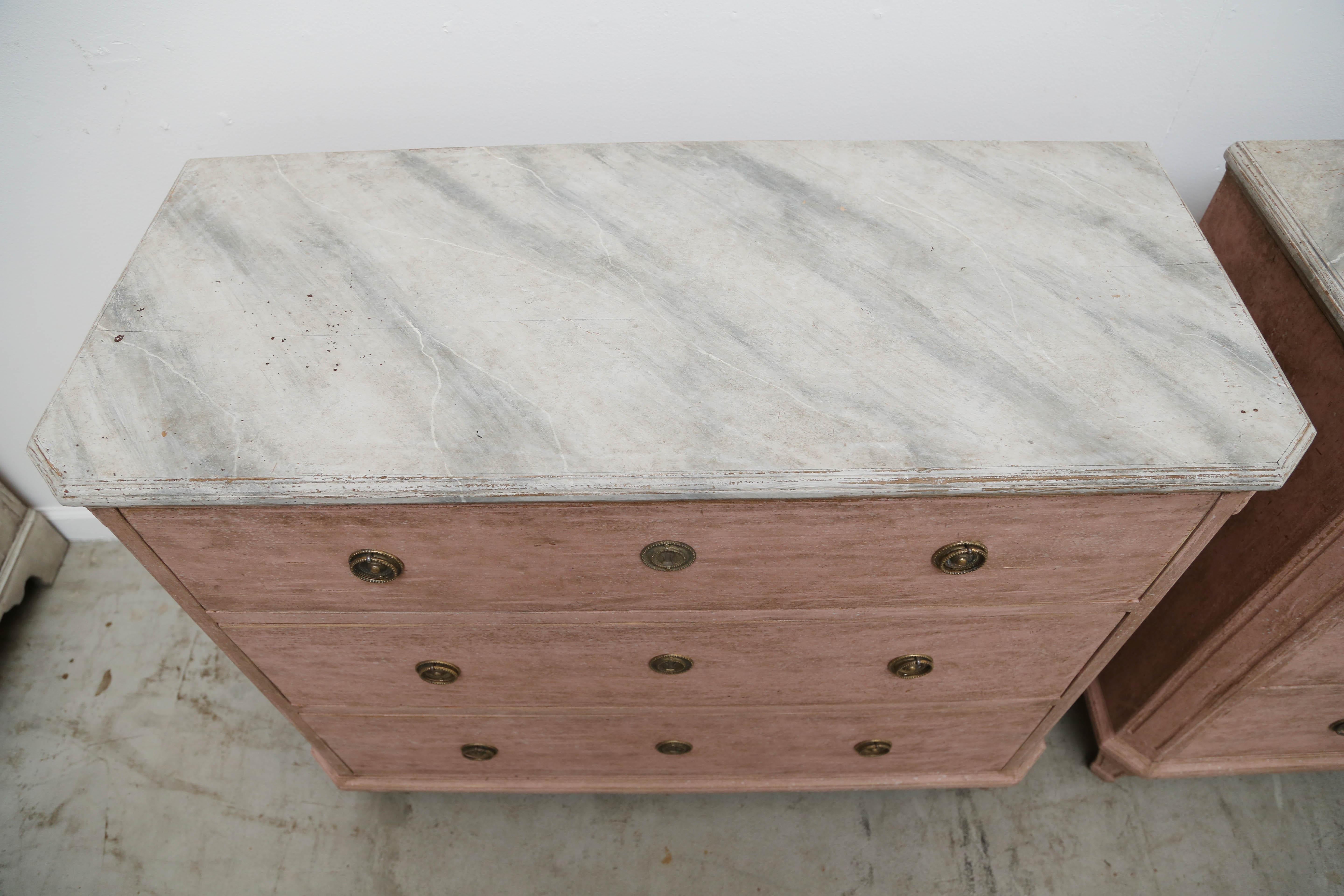 Pair of antique Swedish Gustavian style rose distressed painted chests. The tops are faux painted in greyish marble and extends down to the carved crown border, cut fluted carved corners ending with a rosette, threes drawers, and tapered fluted