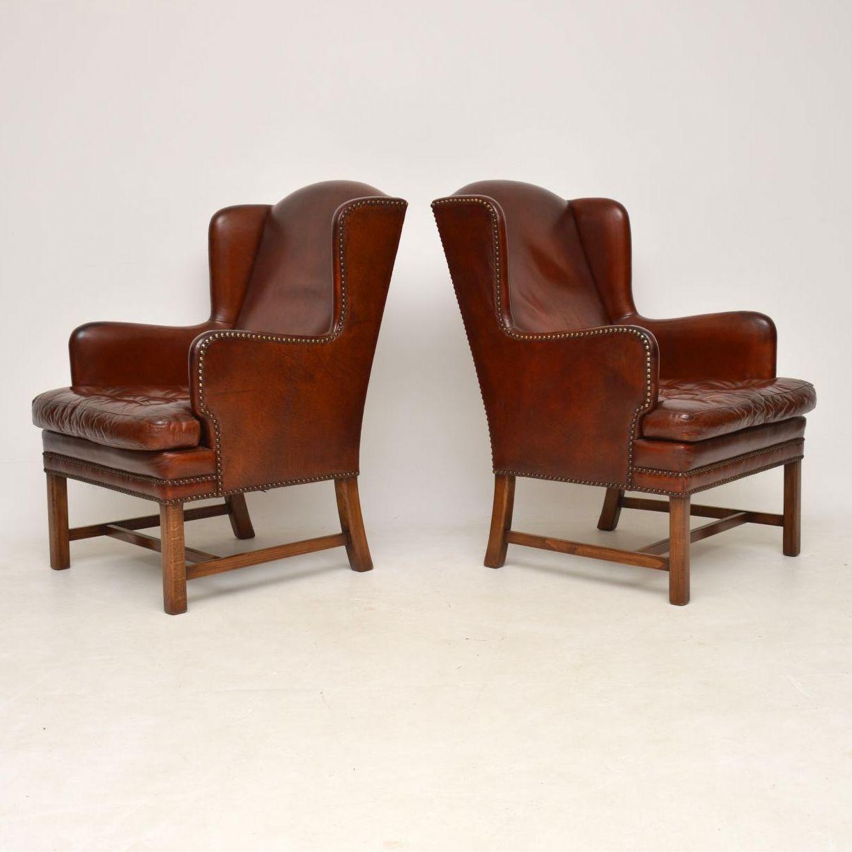 Pair of antique Swedish leather wing armchairs in good original condition and with naturally aged original leather. The leather has a lovely rich color, with hand tacking and buttoned seat cushions. These armchairs are very sturdy and have cross