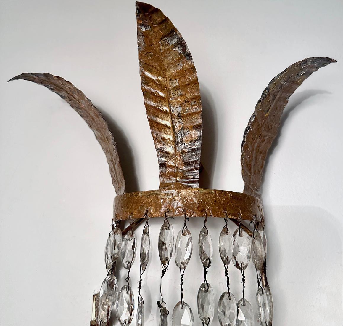 Coppia di appliques in metallo dorato e cristalli del 1900 circa, patina originale.

Misure:
Altezza: 32
