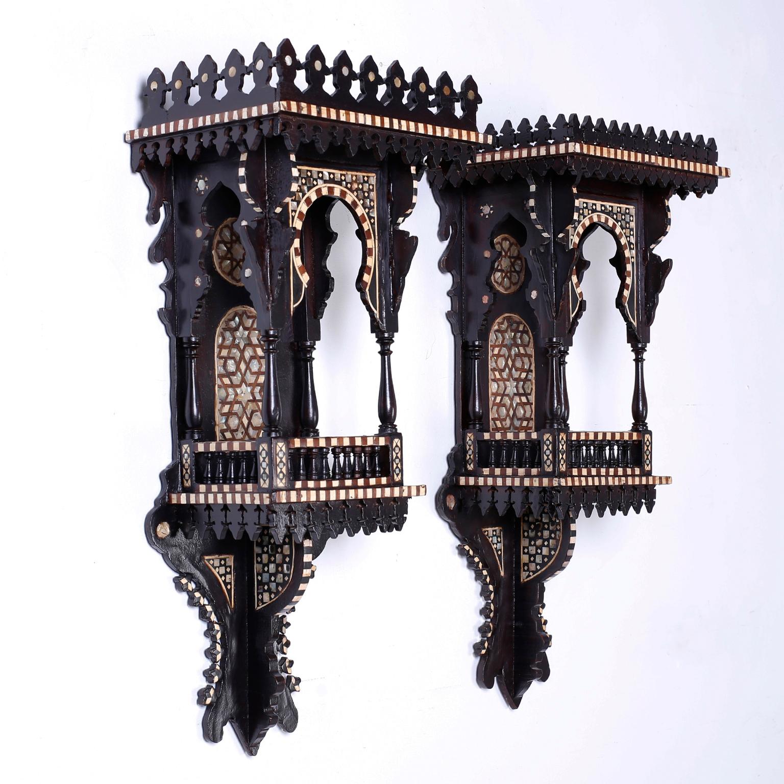 Pair of antique carved wood and ebonized wall brackets with an intriguing architectural form. Featuring a gallery around the top and a balcony complete with balustrades, columns and Moorish arches. Highlighted with inlaid geometric mother of pearl