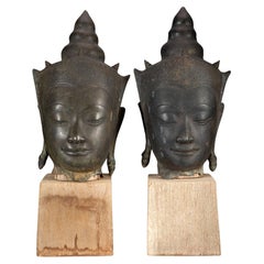 Paire d'anciennes têtes de bouddha couronnées en bronze de la période d'Ayutthaya sur un stand en bois 