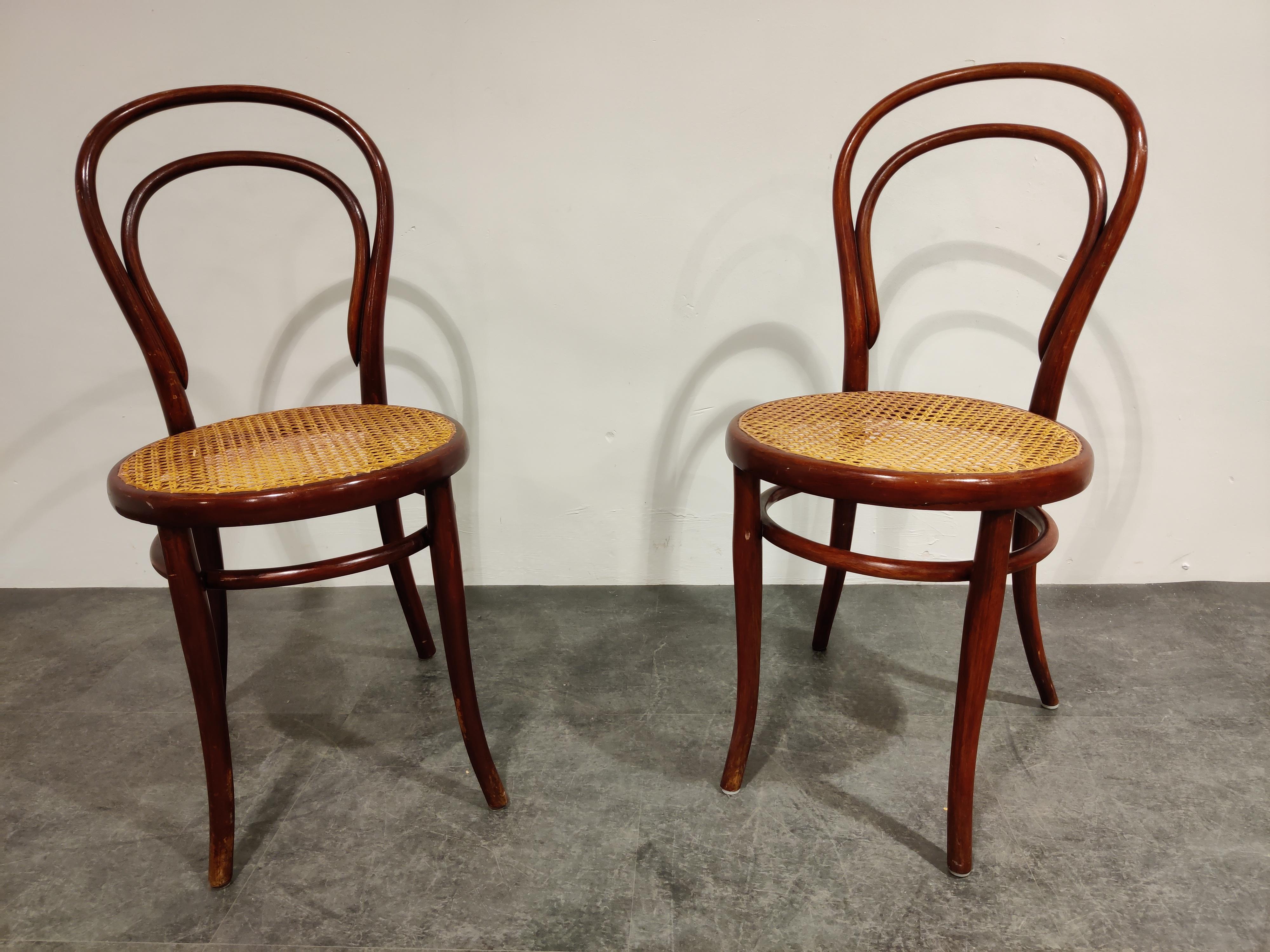 Pair of dark brown bentwooden dining chairs.

Stamped Thonet

We date them at early 1950s.

The cane seats are in good condition.

Dimensions:
Height 90cm/35