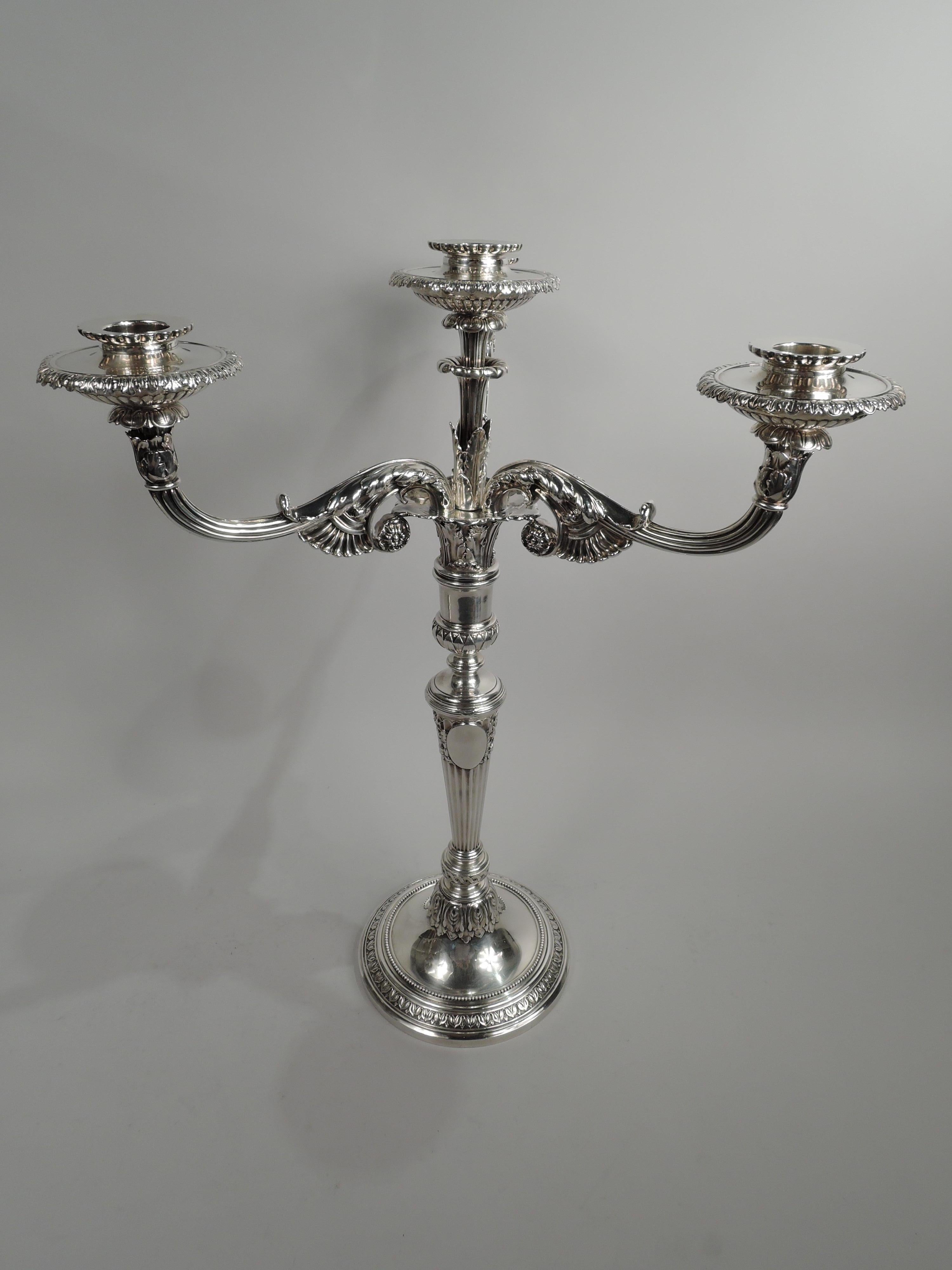 Pair of fine and elegant French Classical sterling silver 4-light candelabra. Made by Tiffany & Co. in New York, ca 1910. Each: Tapering and fluted shaft applied with 2 ovals (vacant) on raised foot flanked by oak leaves. Raised and stepped foot.