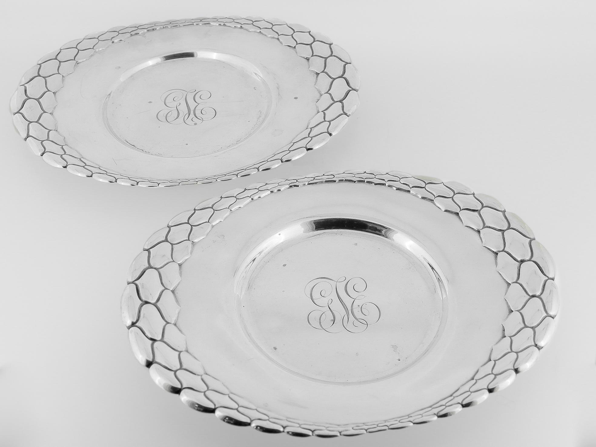 A fine pair of antique sterling silver plates or salvers.

In sterling silver.

By Tiffany & Co.

Each with a raised pattern around the circumference of the rim.

With a stylized cursor 