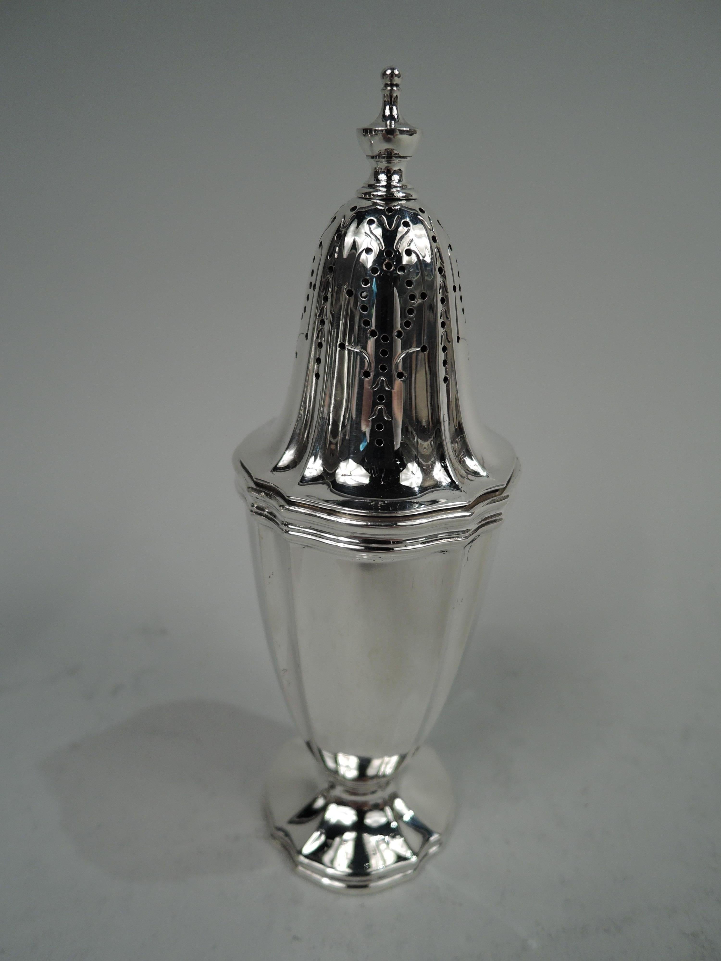 Pair of Edwardian Classical sterling silver salt and pepper shakers. Made by Tiffany & Co. in New York, ca 1910. Each: Tapering ovoid body on raised foot. Cover dimed with ornamental piercing and vasiform finial. Fluting and reeding. Fully marked