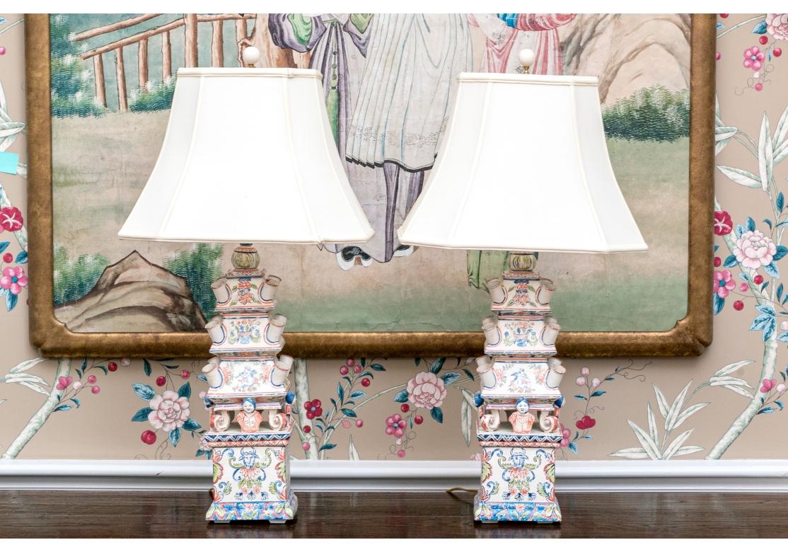 Une paire de lampes colorées et élégantes. Paire de lampes en métal lourd en forme de pagode avec des ouvertures multiples pour les fleurs, maintenant montées comme lampes. Les lampes sont décorées en rouge, bleu, vert avec Bacchus, des angles, des
