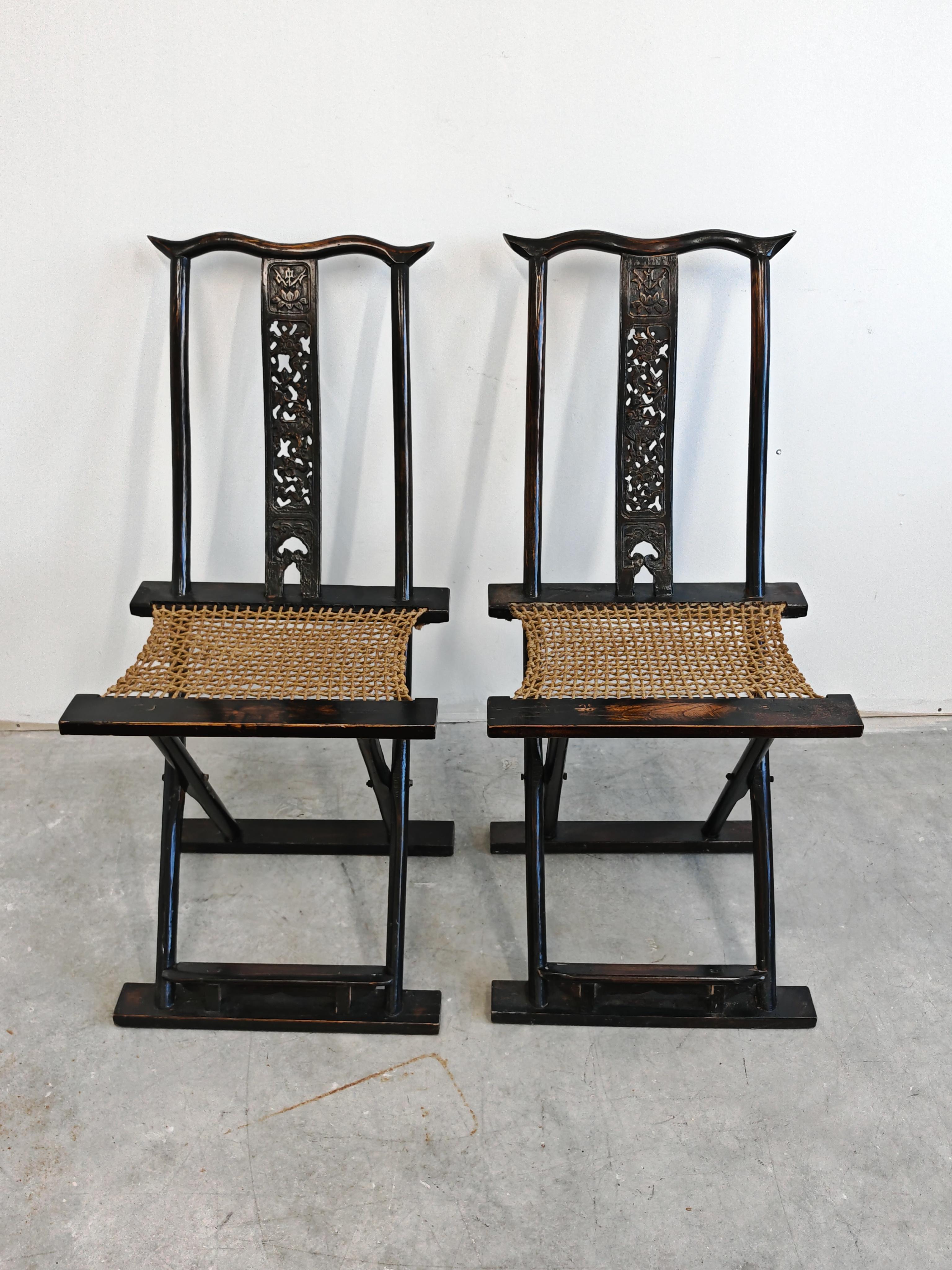 Vous trouverez dans cette annonce une paire de chaises pliantes chinoises anciennes. Ils sont réalisés en bois sculpté à la main, avec des sièges en corde tressée. Souvent appelées chaises de voyage, ces chaises d'appoint seront un complément