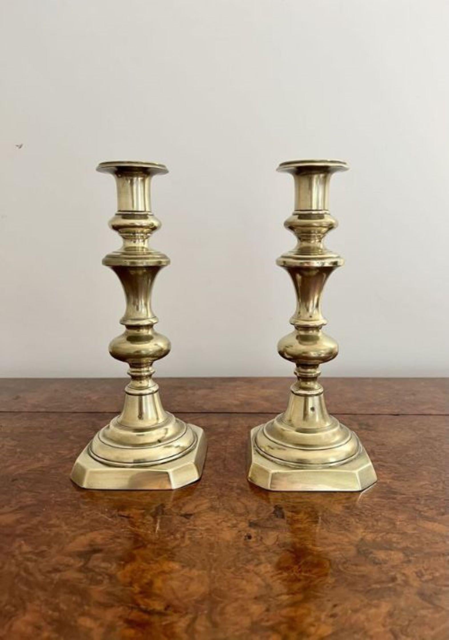 Pair of antique Victorian brass candlesticks having a pair of Victorian candlesticks with shell shaped bases, shaped columns, circular drip trays & ring turned engraving. 