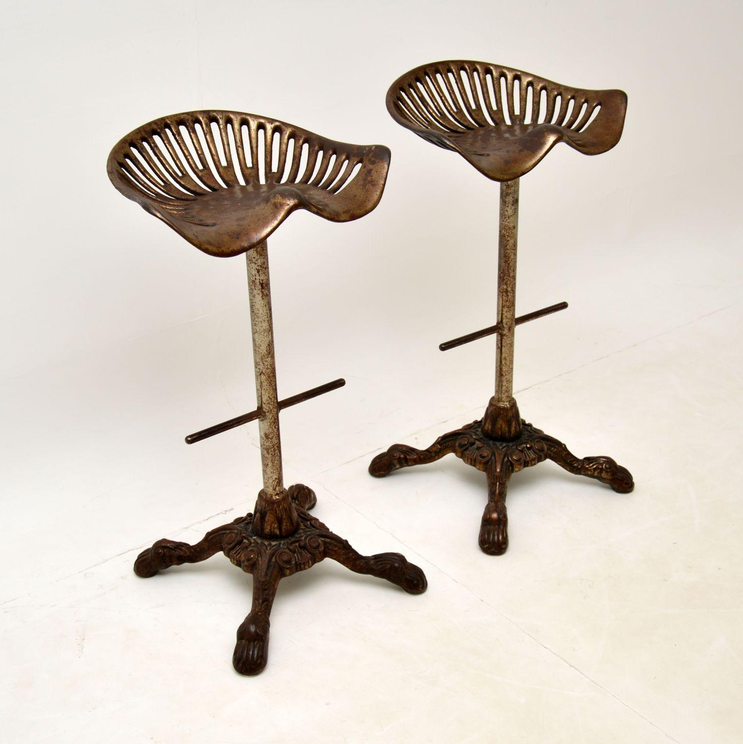 A fantastic pair of Victorian iron bar stools with adapted tractor seats. These were made in England, they date from the 1880-1900 period.

They are of amazing quality, the seats would have originally been from actual tractors and have been fitted