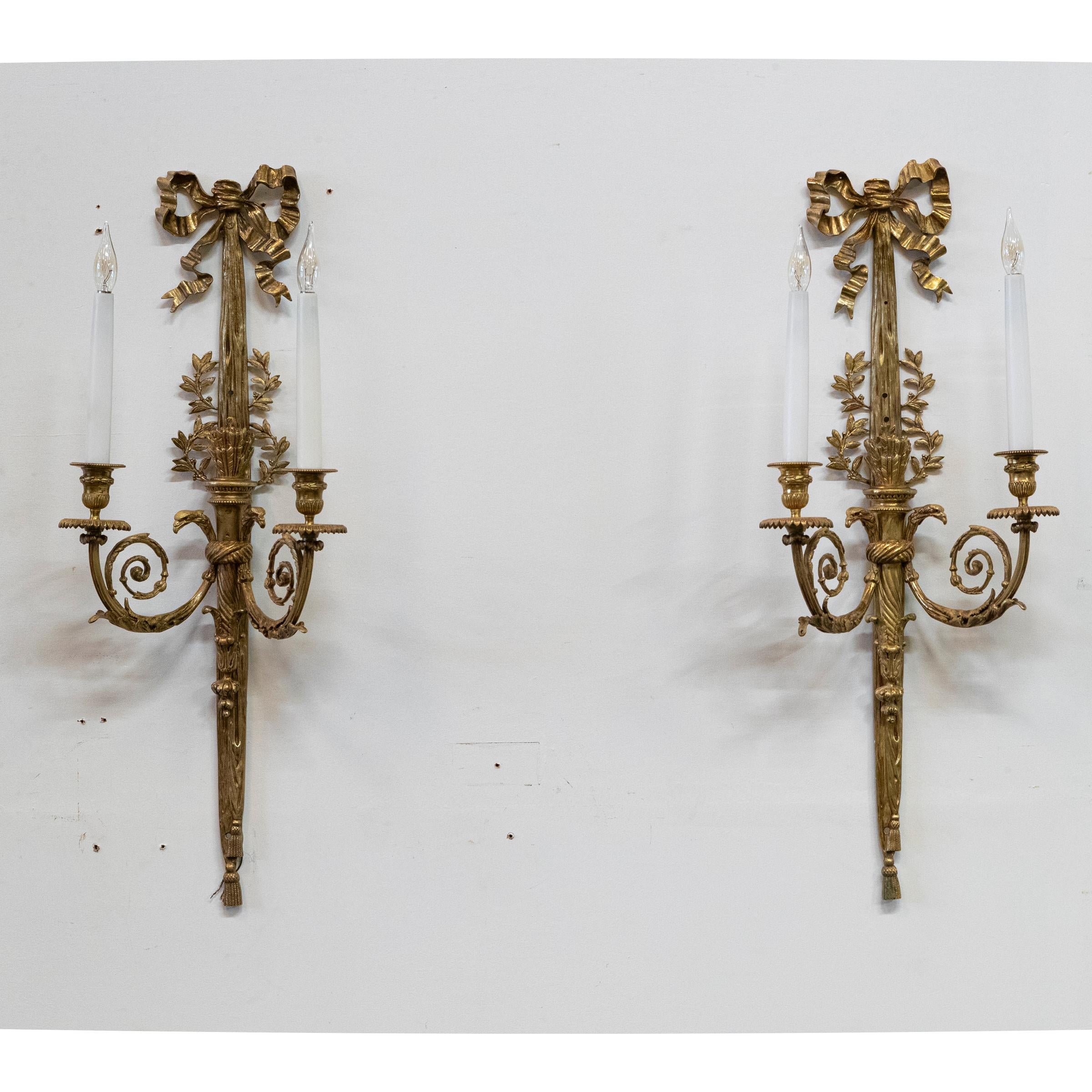 Paire d'élégantes appliques murales en bronze doré d'origine victorienne 

Les pièces opulentes sont ornées d'un délicat nœud de ruban qui couronne le sommet, tandis que des motifs complexes de feuilles et de fleurs courent le long de la colonne