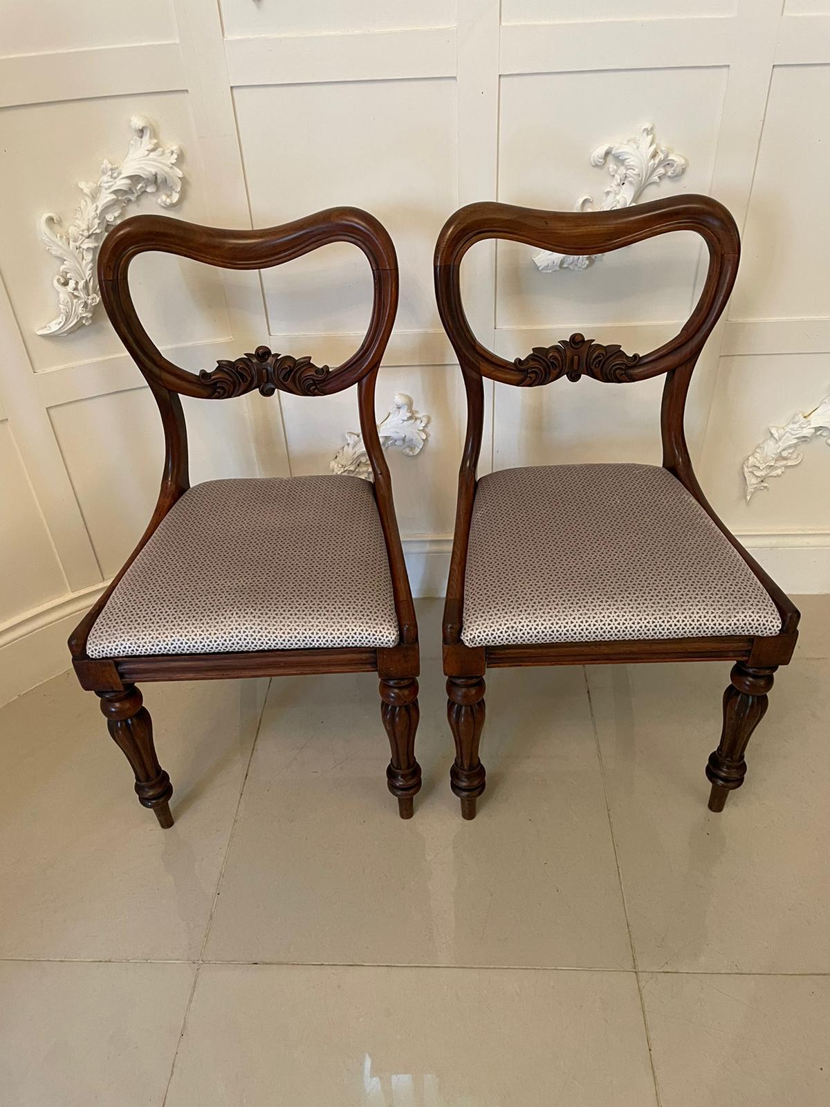 Pair of antique Victorian mahogany side chairs having a pretty shaped top with a carved shaped splat to the centre of the back, newly reupholstered drop-in seats in a quality fabric and standing on shaped reeded legs to the front and out swept back