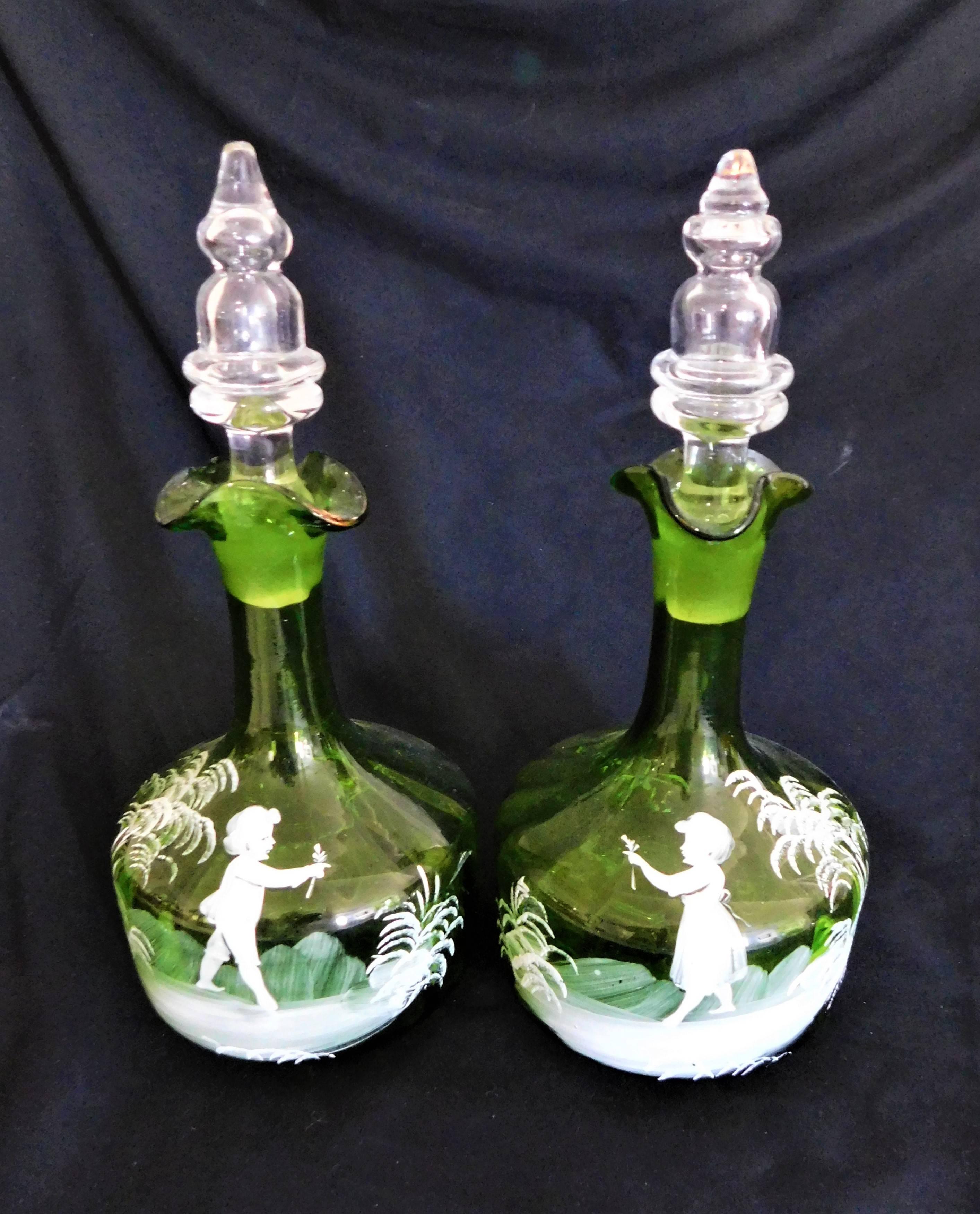 This is a pair of English handblown and hand-painted Mary Gregory decanters, circa 1880, each decanter has a different design.