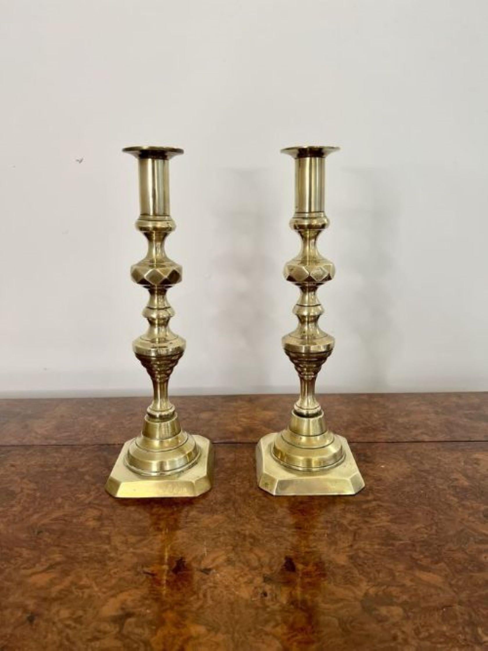 Pair of antique Victorian quality brass candlesticks having a quality pair of brass Victorian candlesticks with a turned shaped columns on a stepped base.