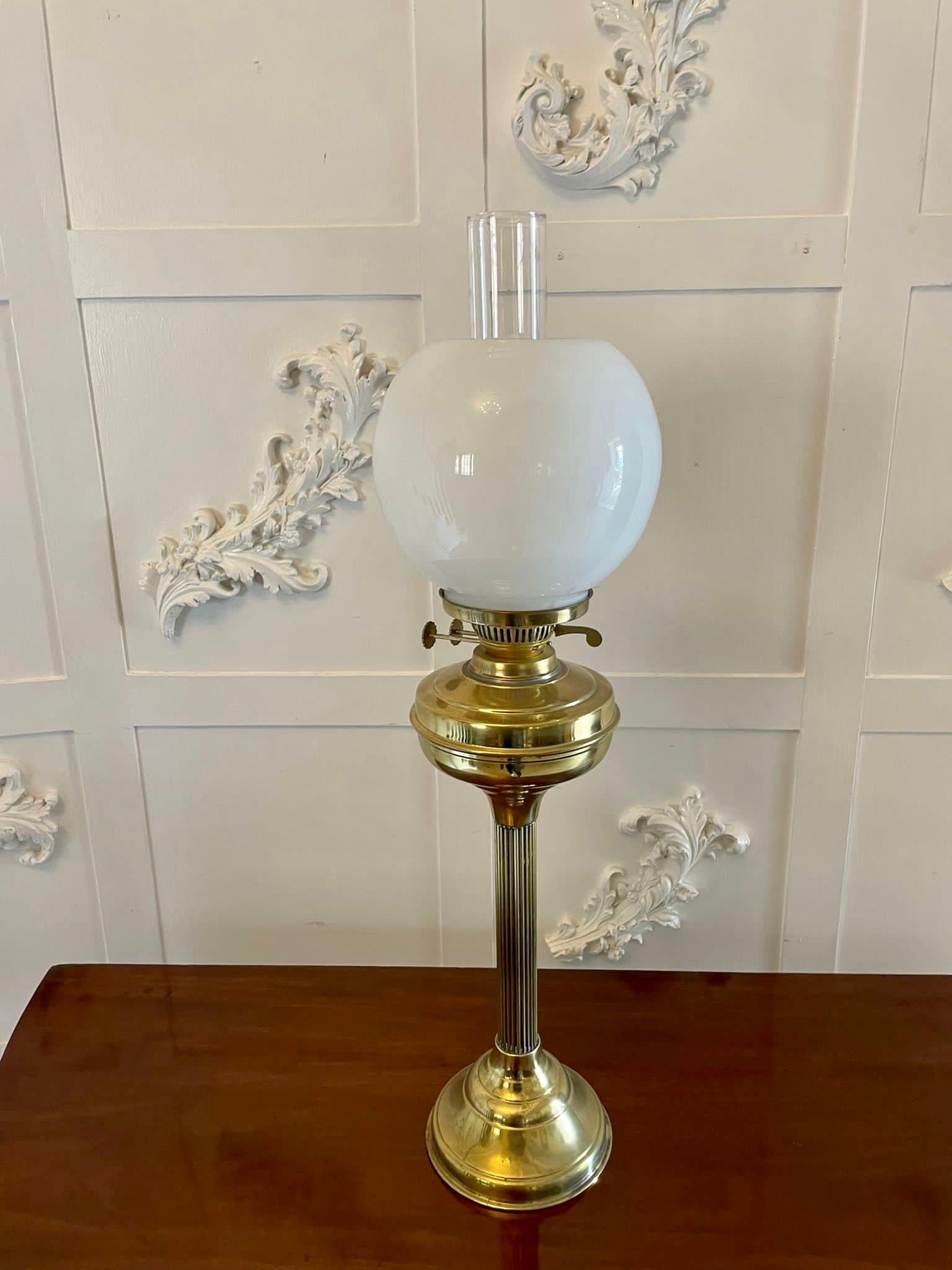 Unusual pair of antique Victorian oil lamps with original glass shades and chimneys, double burner, brass font supported by a reeded column standing on a stepped circular brass base

A wonderfully decorative pair in lovely original