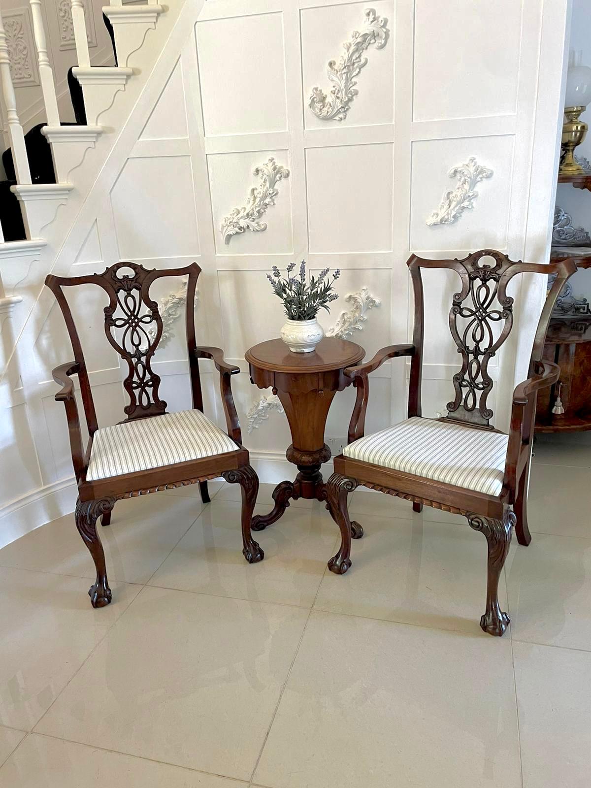 Pair of antique Victorian quality carved mahogany desk chairs having a quality shaped carved mahogany top rail, shaped pierced carved splat to the centre, shaped open arms with shaped supports newly reupholstered drop in seats in a quality fabric,