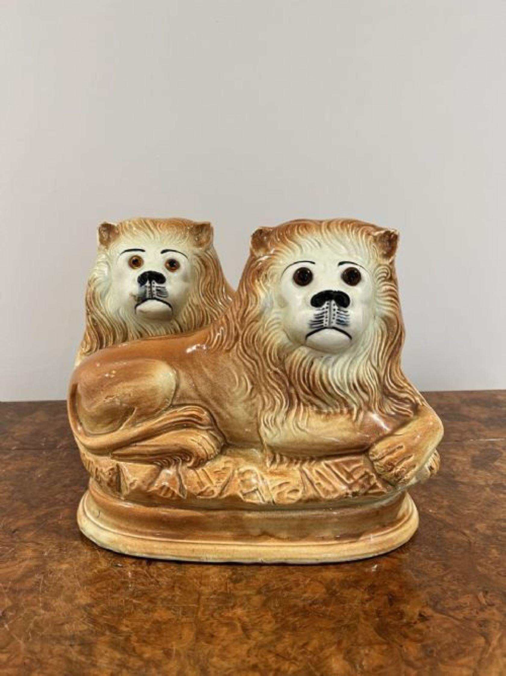 Pair of antique Victorian Staffordshire recumbent lions having glass eyes painted in wonderful orange and brown colours 