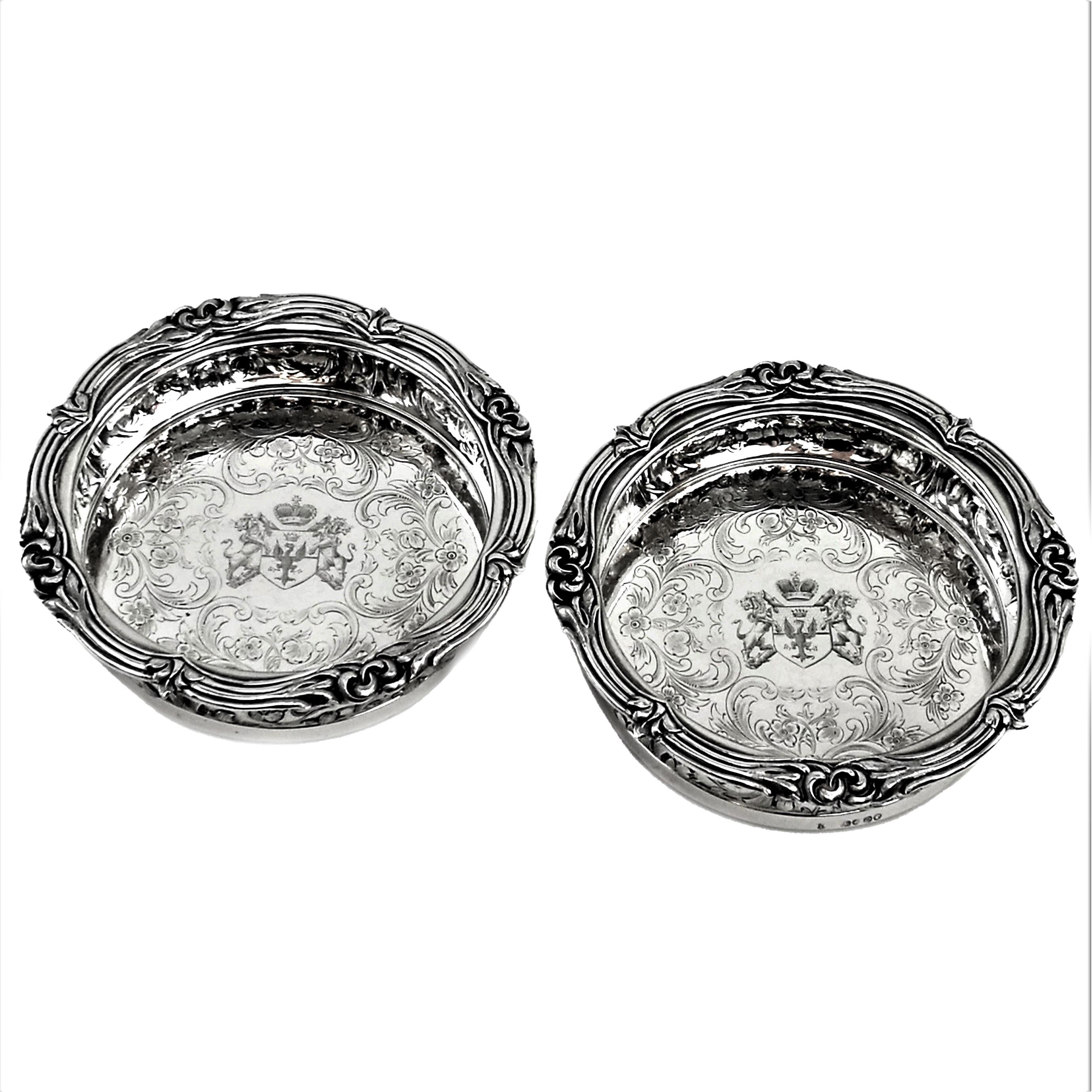 An exceptional pair of Victorian Silver Wine Coasters. These Coasters are of particularly good quality and very heavy weight. These excellent Antique sterling Silver Coasters feature a classic bellied design embellished with a chased floral and