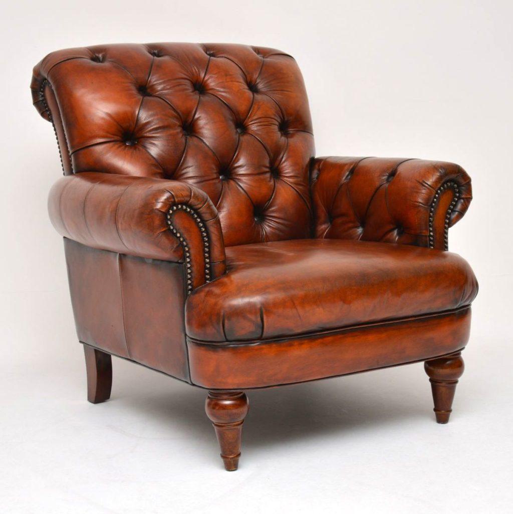 Pair of antique Victorian style deep buttoned leather armchairs sitting on turned mahogany legs. They are deep buttoned on the scroll over back & on the arms. These armchairs have quite large portions & are very comfortable. The color is a lovely