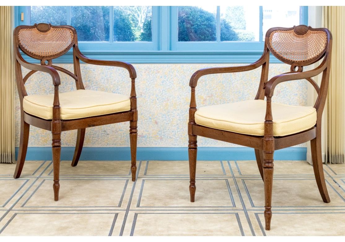 Coppia di poltrone antiche particolarmente leggere e raffinate in stile Art Nouveau  rifinito in noce marrone Chestnut. Le sedie sono caratterizzate da schienali a ventaglio con canne tirate a mano sotto terminali ovali che riprendono le eleganti