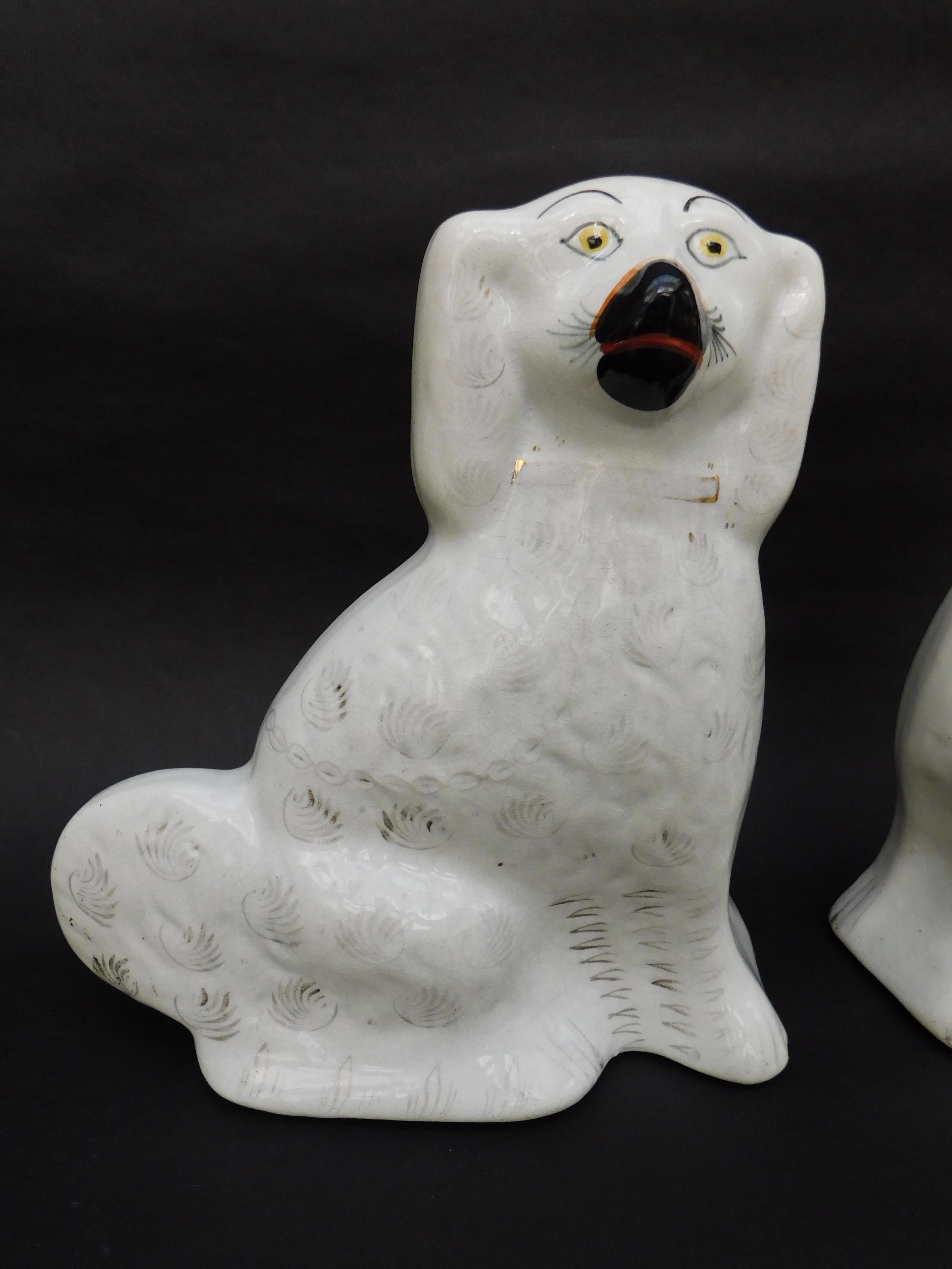 A lovely antique pair of white English Staffordshire porcelain spaniel dogs, circa 1860. This original mirror image pair is in good antique condition (worn gilding). One dog has chips to the feet as shown on the fifth photograph. They would make