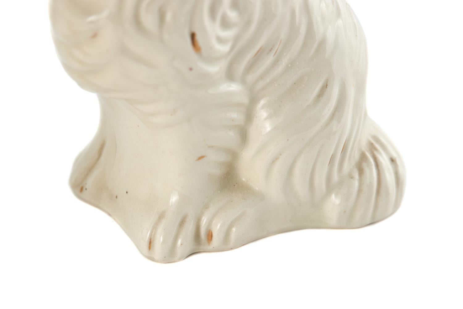 Pareja de Perros de Staffordshire blancos antiguos victorianos en posición sentada, caras pintadas a mano y decoración dorada.