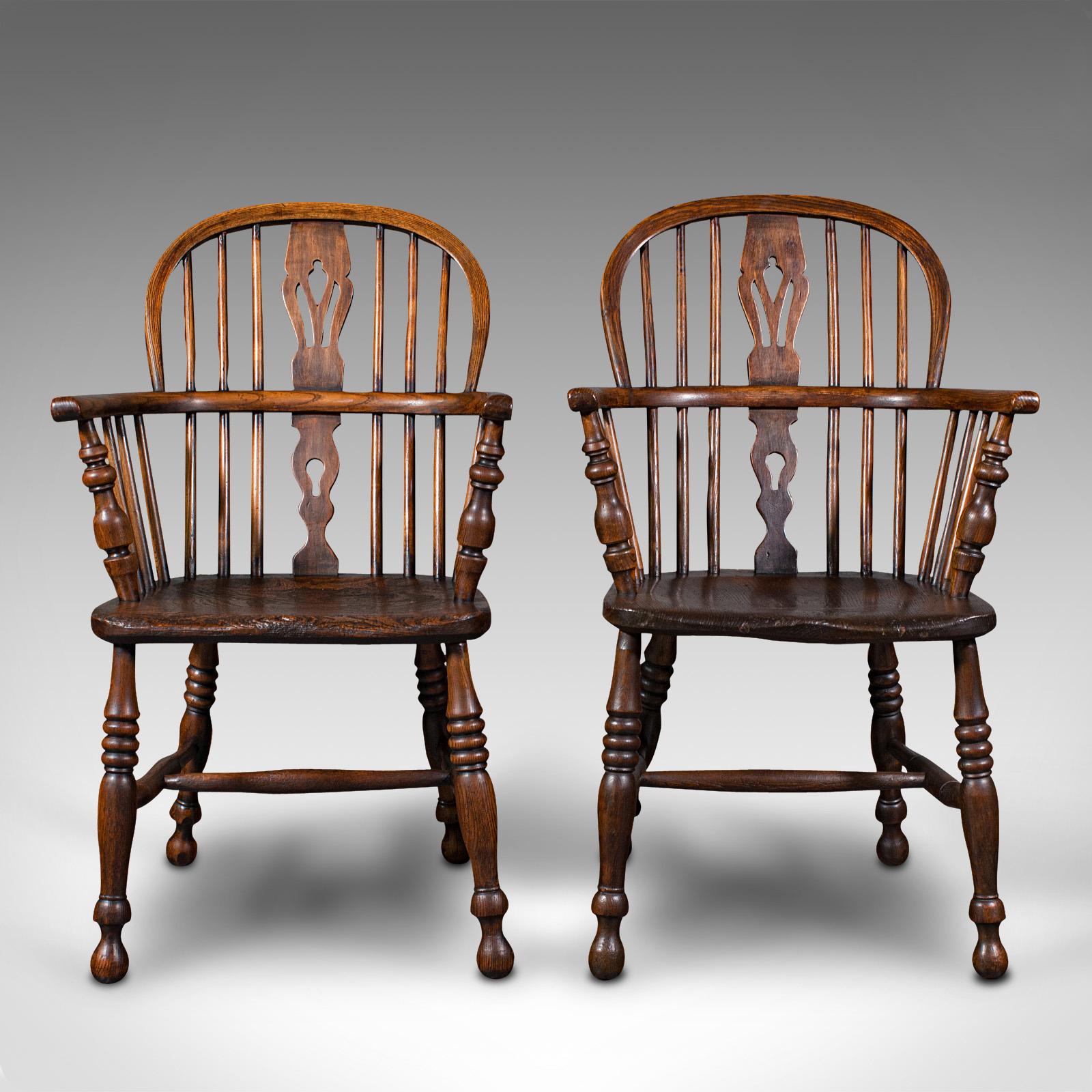 This is a pair of antique Windsor chairs. An English, elm and ash elbow or armchair, dating to the mid Victorian period, circa 1850.

Country house appeal, inviting to be placed at the fireside
Displaying a desirable aged patina and in good