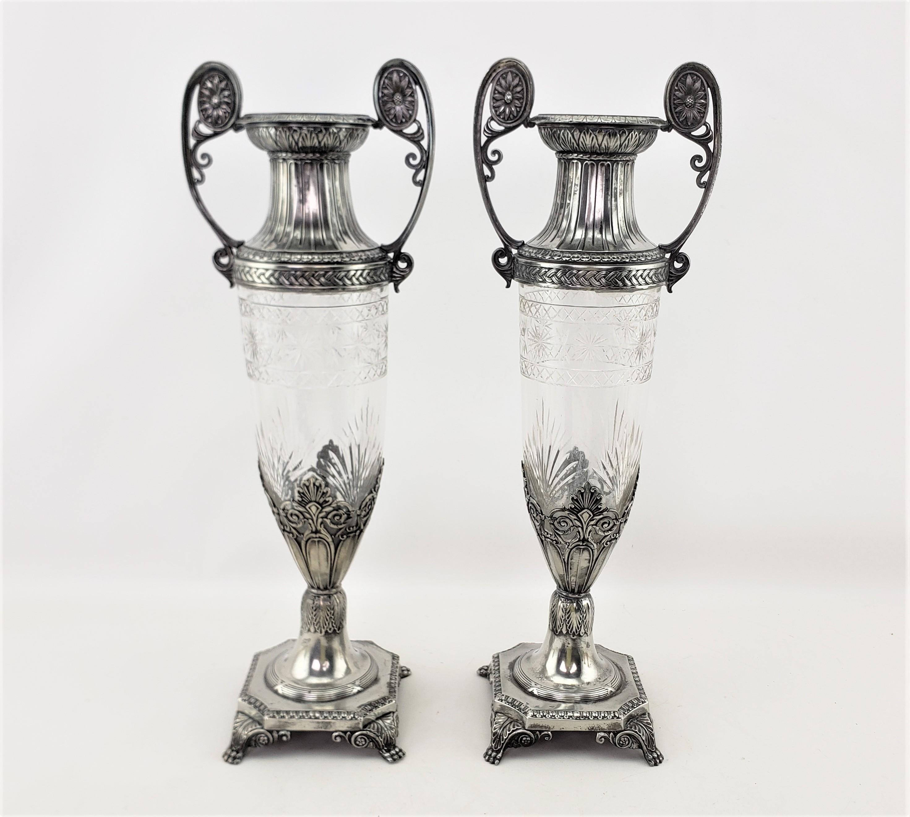 This pair of antique vases were made by the well known WMF company of Germany in approximately 1900 and done in a Seccessionist style. The vases are done with a tapered and cut crystal body with ornate silver plated mounts composing the top, handles
