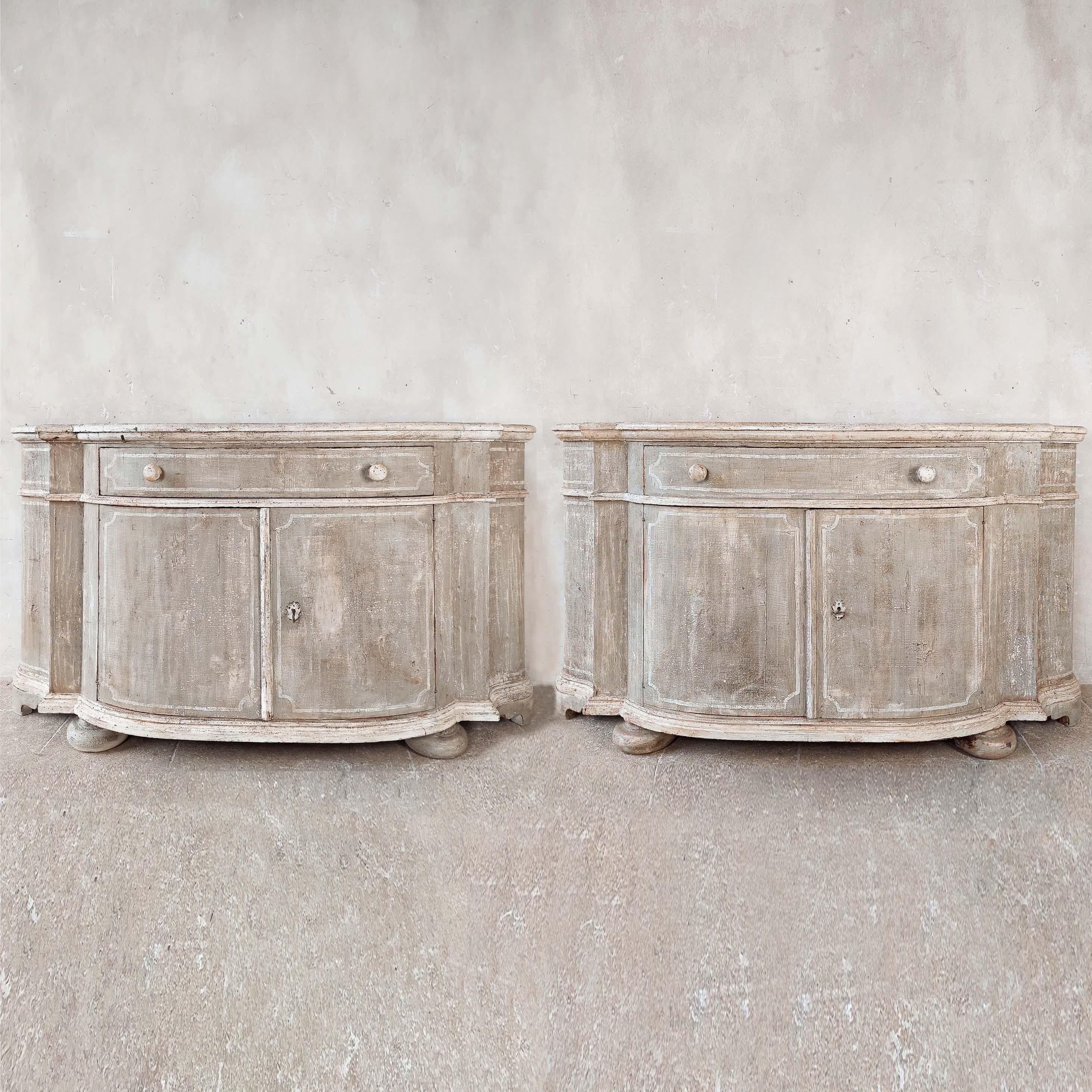Pair of old wooden French cabinets or commodes, later decorated with a beautiful worn light warm gray and cream-colored patina.

dimensions: h 101 x w 185 x d 52 cm

price for the pair