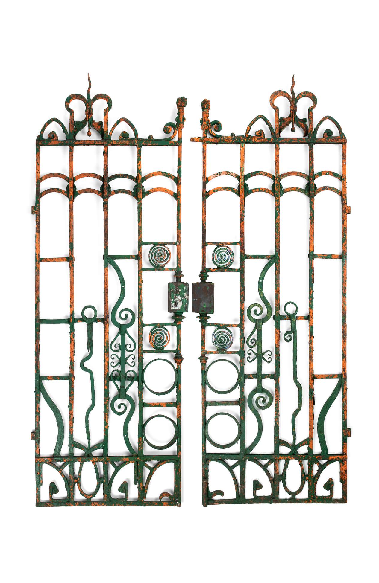 A superb pair of wrought iron entrance gates in original flaky paint. With scroll design features and twisting railheads leading to balustrade and concentric circle rosettes. Blacksmith forged in wrought iron with lock and hinge brackets present.