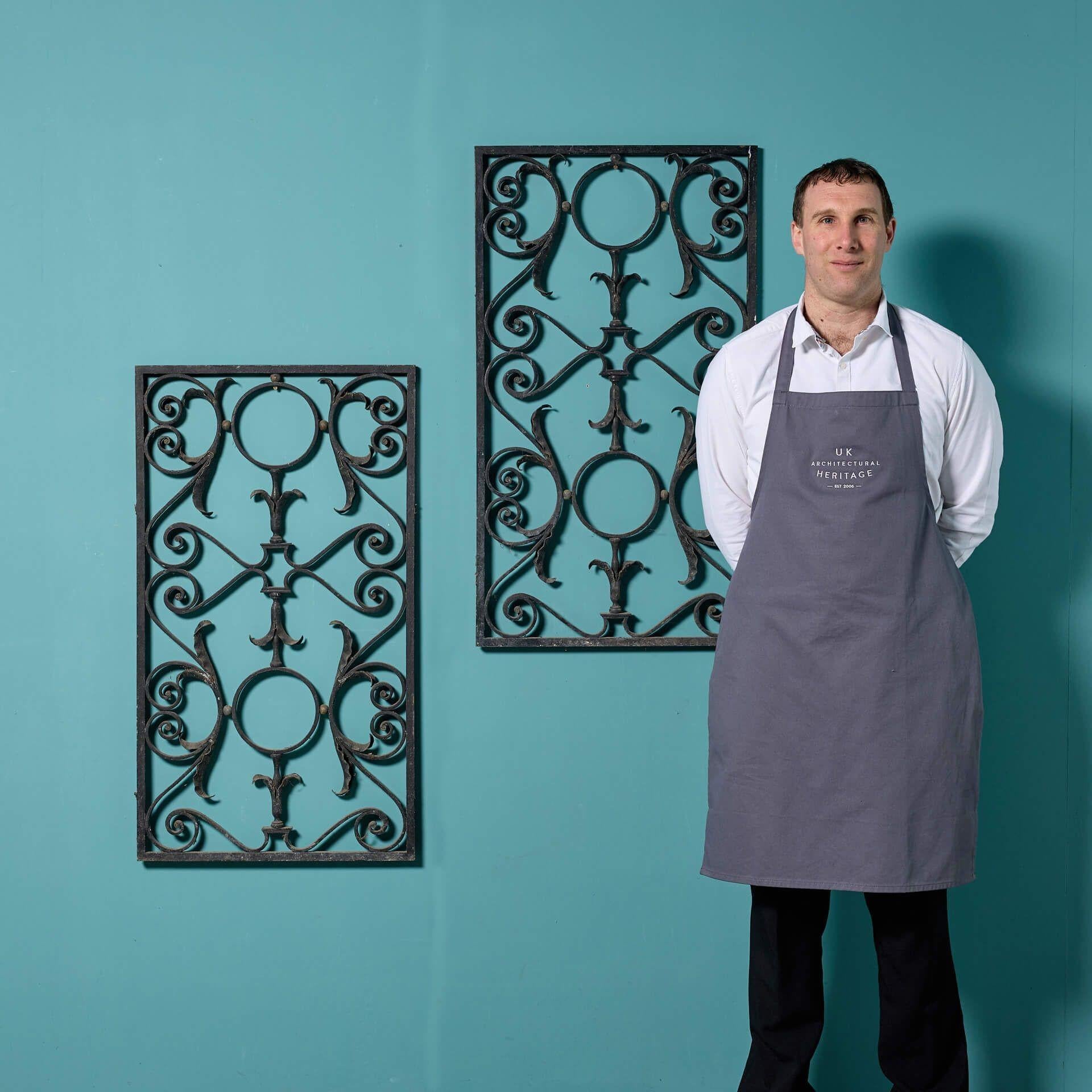 A pair of antique wrought iron panels. These panels are an ode to their English Blacksmith, made from wrought iron with an unusual elegant scrolling leaf and foliage design. In Georgian style, these panels could be used decoratively in a period