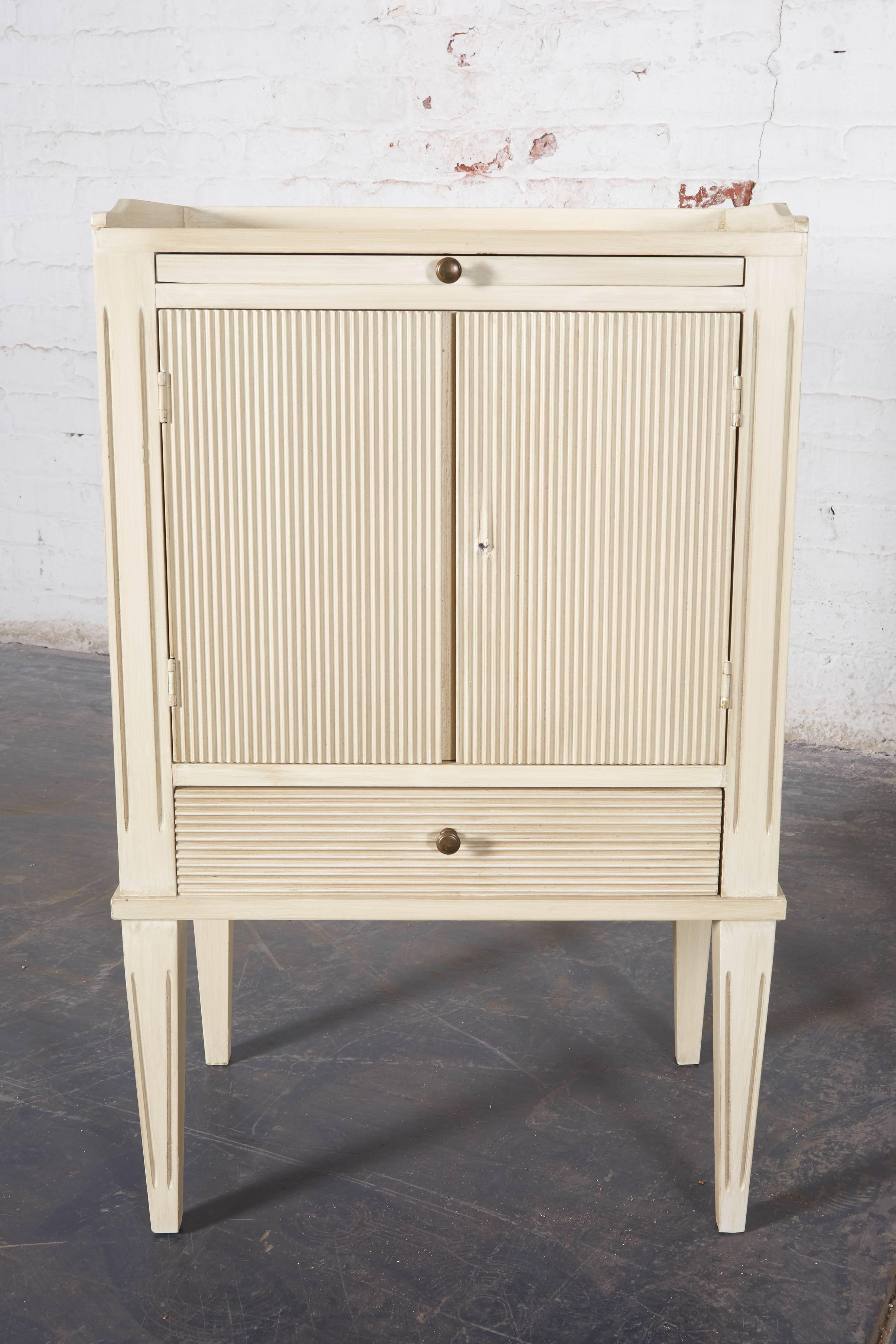 Each top with three-quarter gallery over a pull-out shelf, two-door cabinet with fluted fronts, and single drawer; raised on tapering legs.