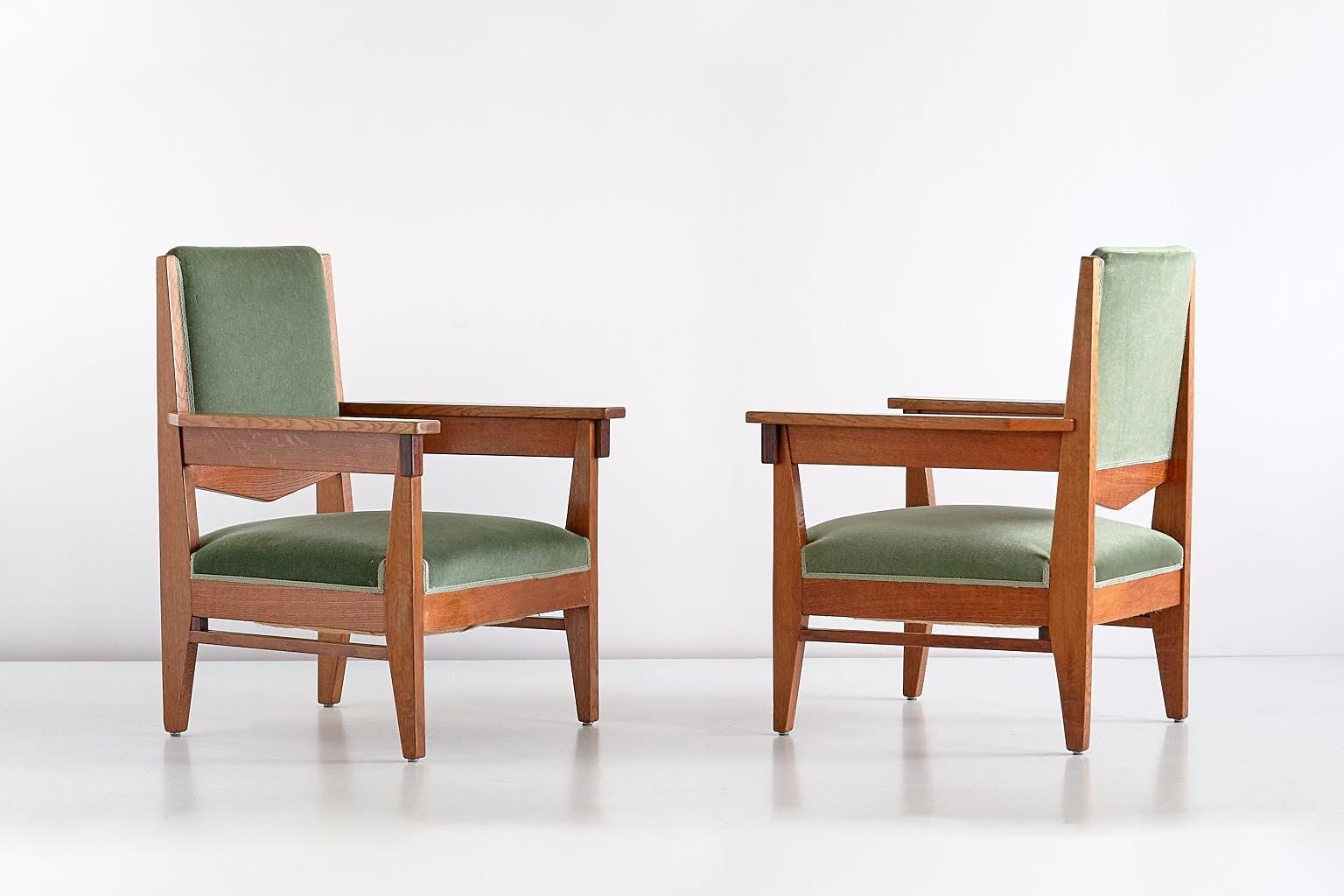 Dieses seltene Sesselpaar wurde von Anton Lucas entworfen und um 1925 in Leiden, Niederlande, hergestellt. Die Rahmen sind aus massivem Eichenholz gefertigt, mit einem geometrischen Frontdetail aus Makassar-Ebenholz. Die Stühle behalten ihre