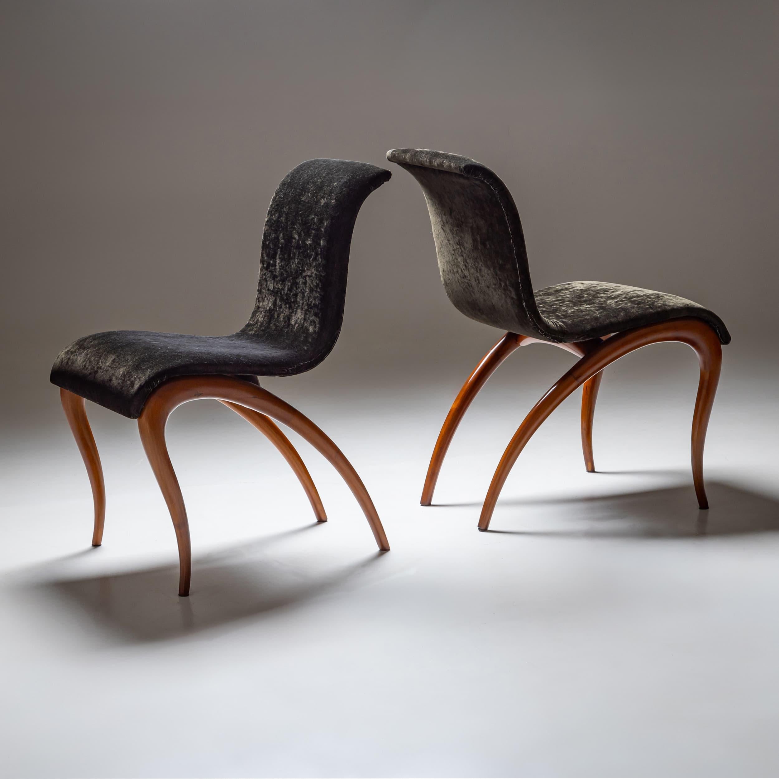 Una coppia di sedie scultoree disegnate da Maurizio Marconato & Terry Zappa per Porada negli anni 2000. Le sedie poggiano su gambe in legno affusolate e ricurve e presentano sedute fluide e ondulate che ne esaltano la forma dinamica ed