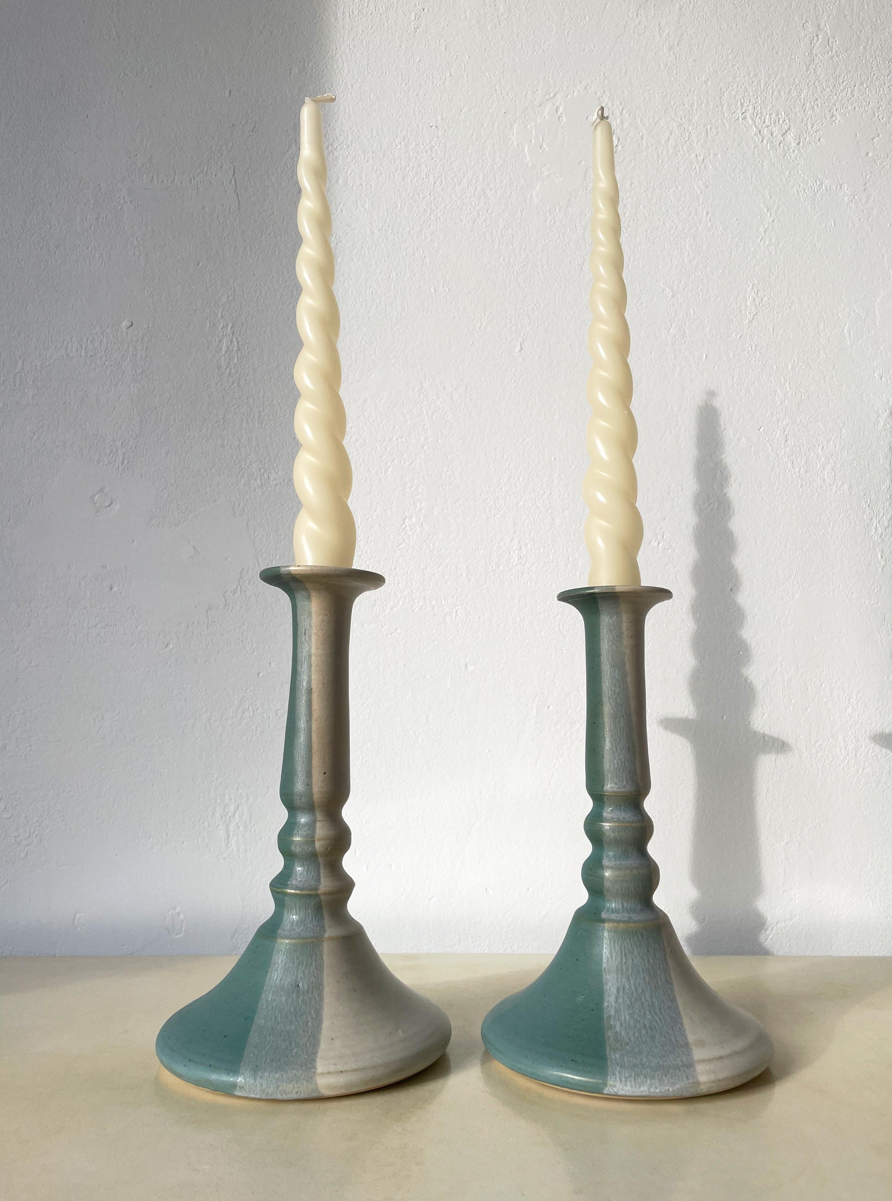 Set of two midcentury Scandinavian Modern ceramic candle holders in aqua and white colors. Vertical striped glaze in light beige white, aqua and green. Each handmade and unique - one item is slightly shorter than the other. Signed under base.
