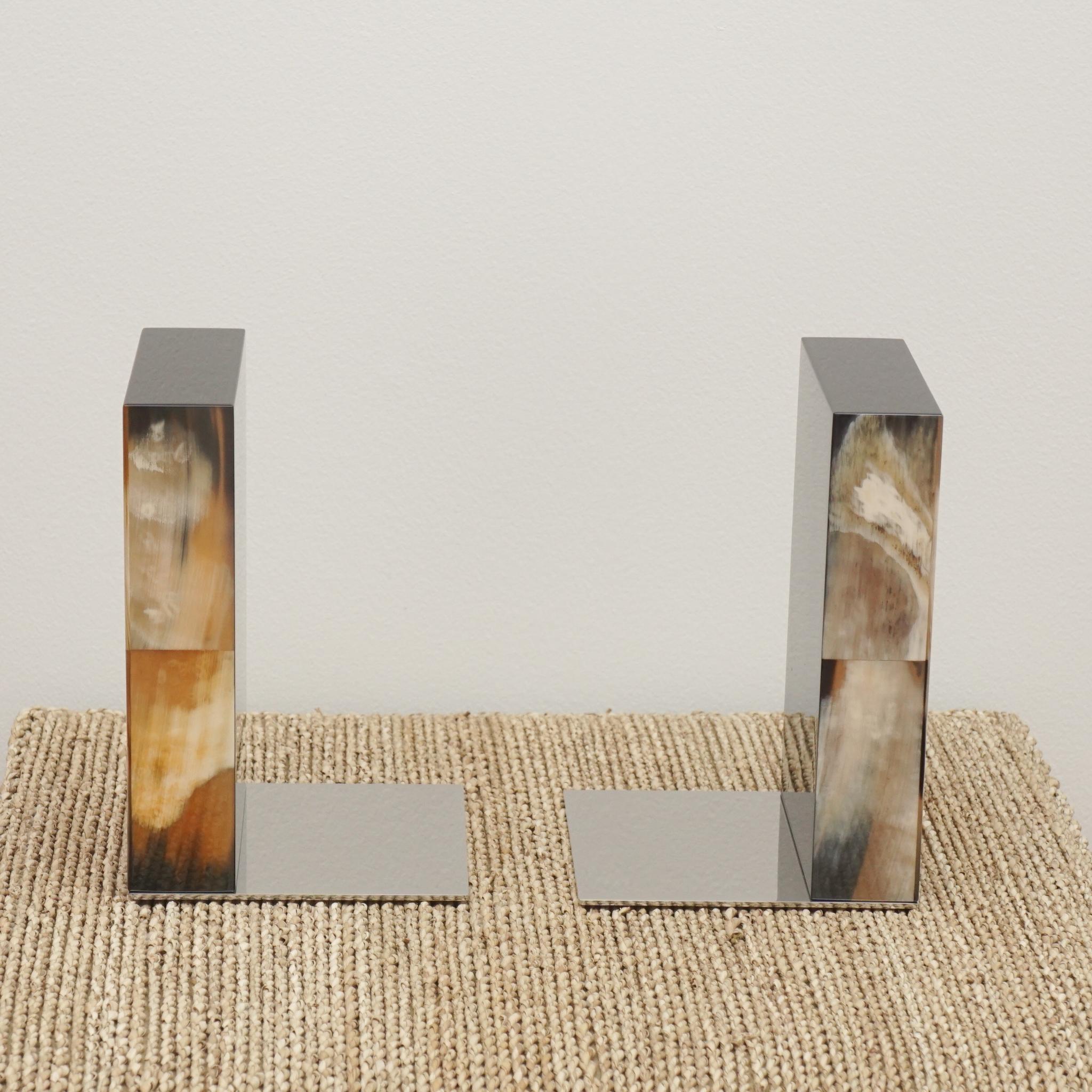 The Igor bookends, shown here from Arcahorn, reflect the company's tradition of combining natural materials and intricate craftsmanship to create luxury goods. The bookends are handcrafted from light cow horn and wood with ivory gloss finish. The