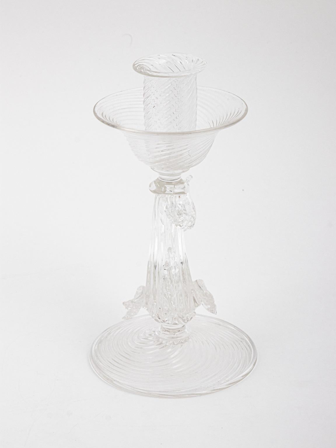 Pair of candlesticks by Archimede Seguso, Murano, circa 1940s. Clear glass, with swirl pattern, fish or dolphin under the candle cup. The candles are approximate 9 inches tall and the base is 5 inches across. Both candles are signed Archimede Seguso