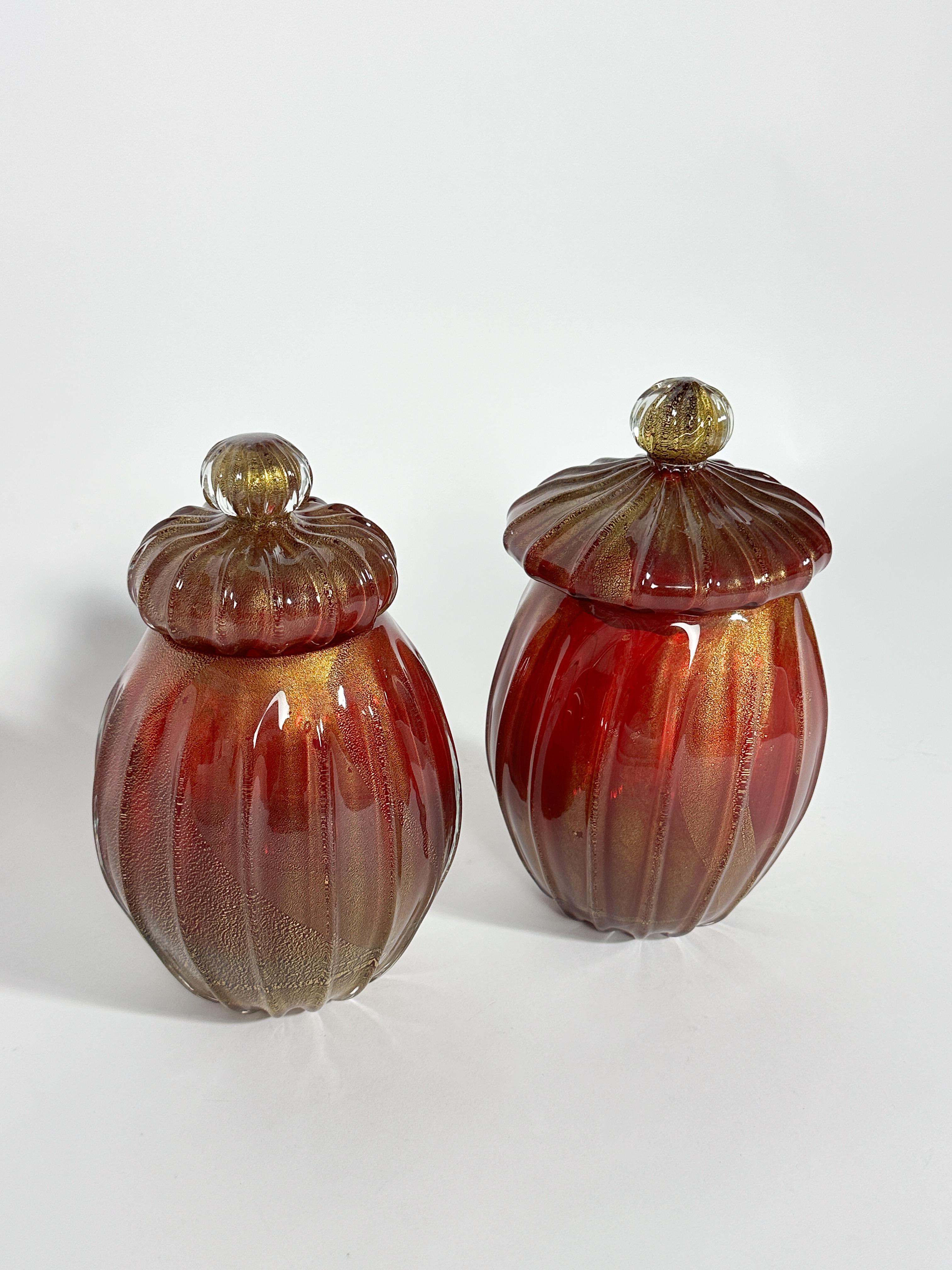 Rara coppia di vasi in vetro di Archimede Seguso di colore rosso corallo scuro con inclusioni dorate, realizzati a mano a Venezia negli anni Sessanta.

Colore vibrante con foglia d'oro scintillante. 

Altezza: 24 cm, 23 cm
Diametro: 14 cm
