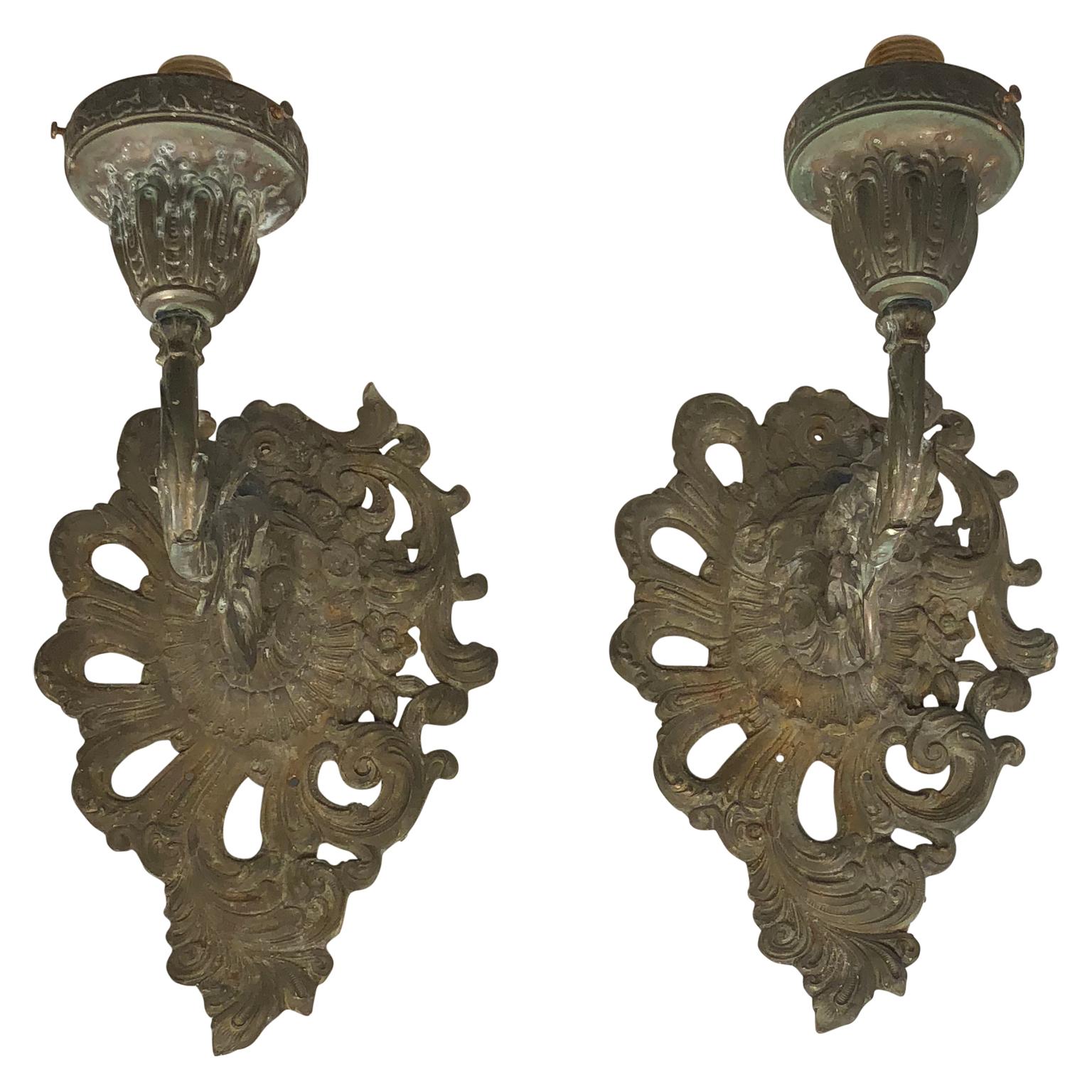 Pair of Iron Rococo wall sconces, brass.
The sconces are classic rococo gilded with scrolled design. Beautiful on a dining room or hallway wall, they make a statement any place in your home. 
Sconces will be newly electrified if needed before