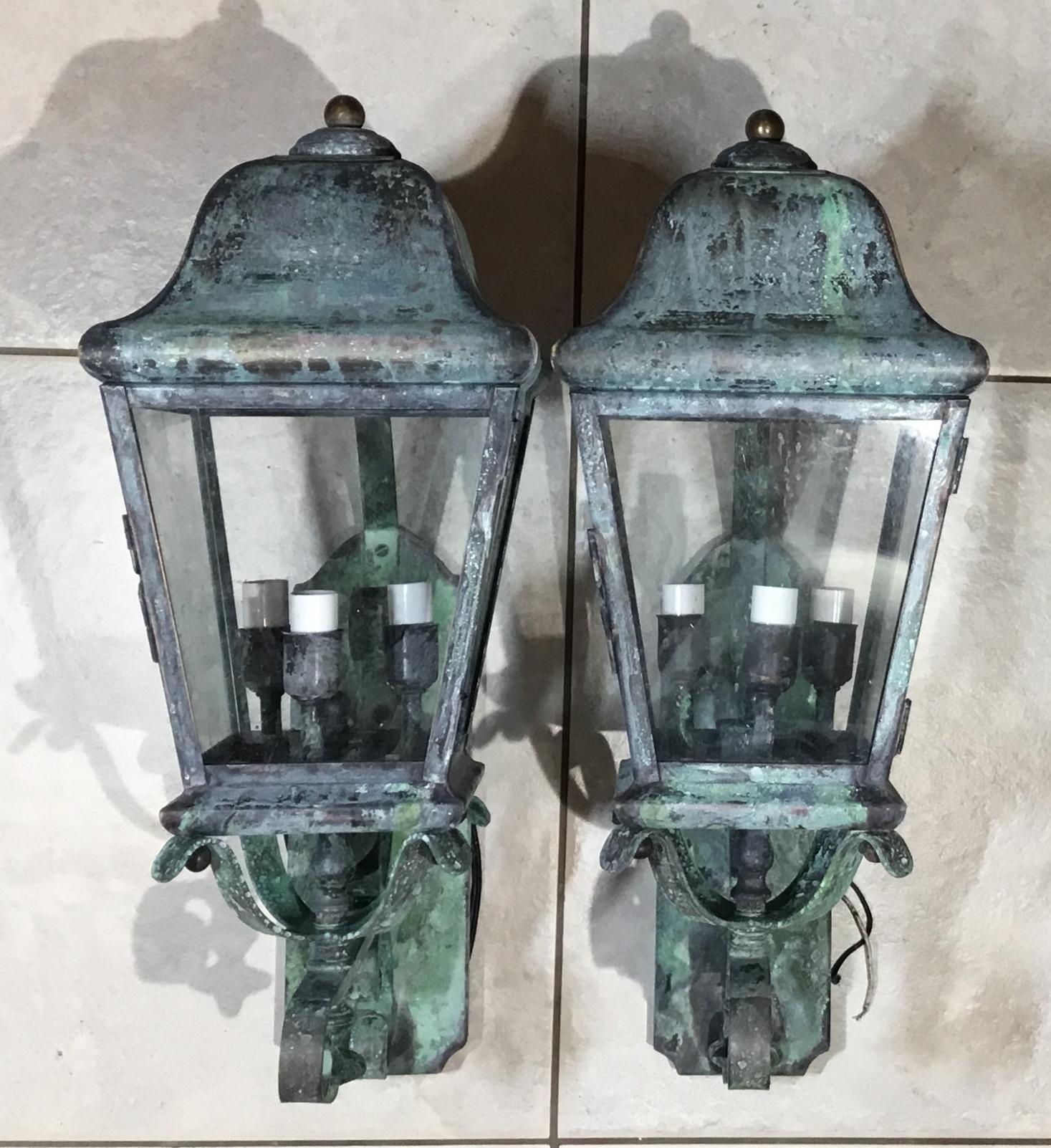 Elegant pair of vintage wall-mounted lanterns made of solid brass, with three 40/watt lights each. Great looking patina and very impressive pair in any front house or indoor space.