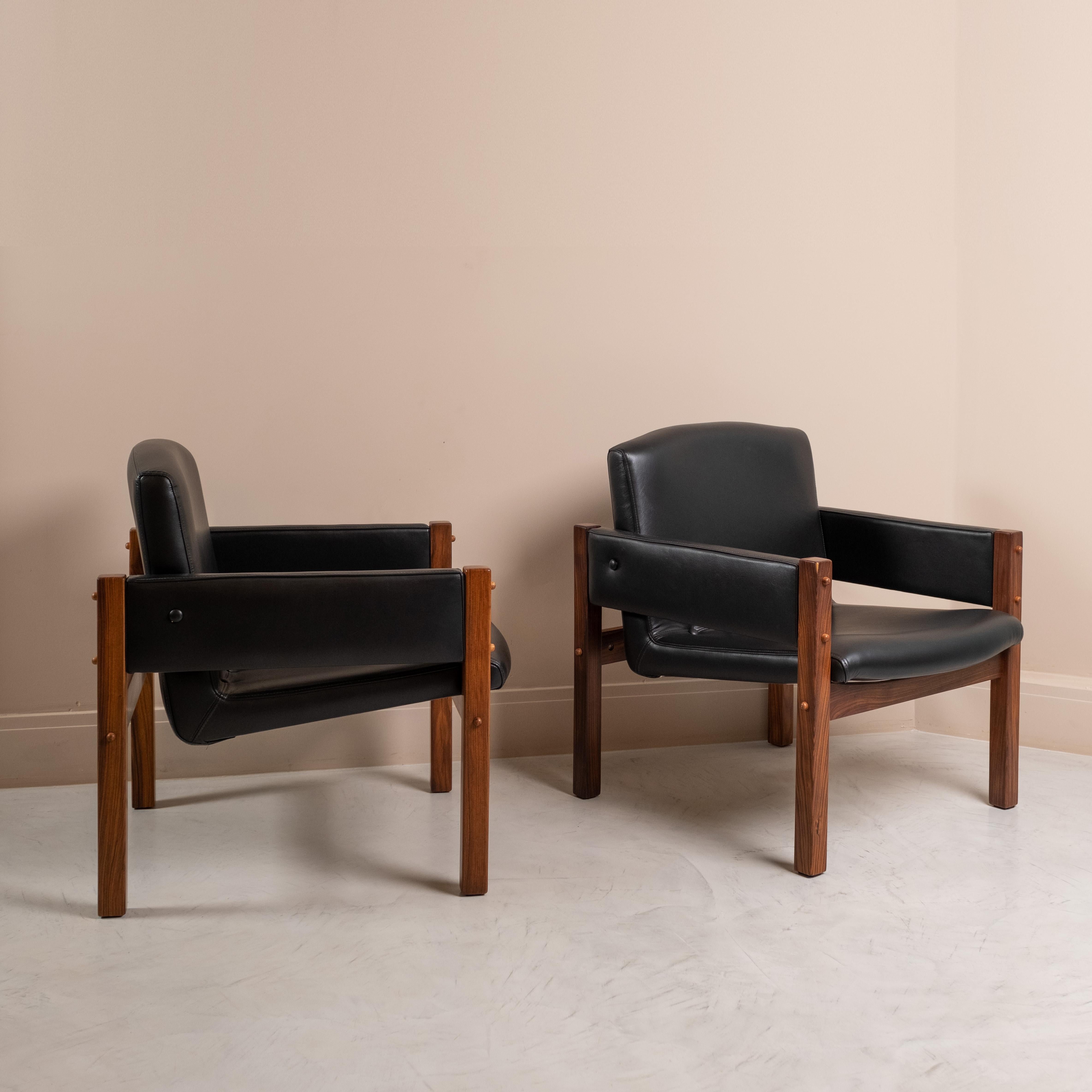 Amazing pair of Arcos  armchairs designed by Sergio Rodrigues in the 1960s for Itamaraty Palace.
They are composed by a solid rosewood structure. The seat and backrest are made up of a single piece.
Pieces entirely restored and covered in black